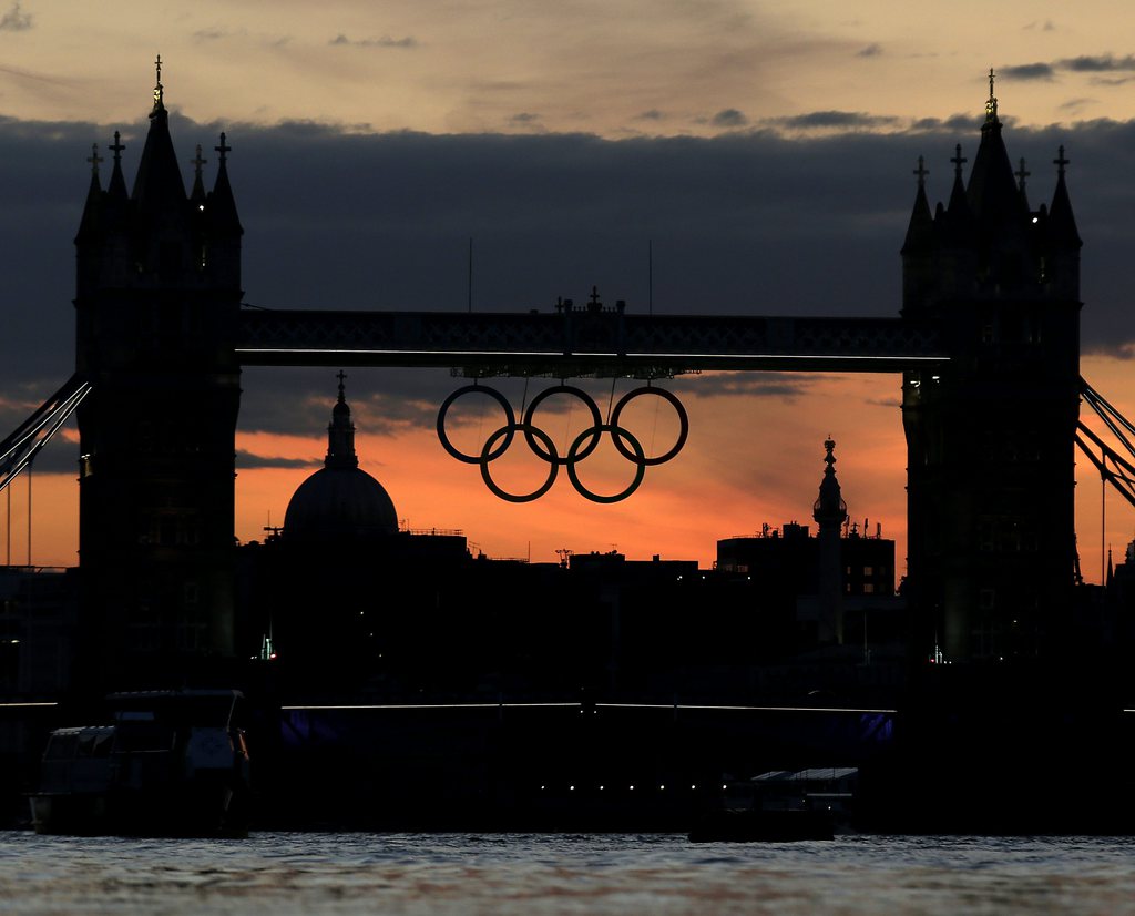 The Olympic rings hang from the Tower Bridge after sunset on Sunday, July 15, 2012, as London prepares for the 2012 Summer Olympics. (AP Photo/Charlie Riedel)