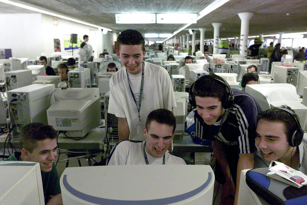 V02 - 20020807 - VALENCIA, SPAIN : A group of young participants at the Campus Party meeting joke while looking at a video on a computer screen at the parking of Sciences and Arts City in Valencia Wednesday 7 August 2002. Thousands of computers and internet supporters met from August 6th to 11th at the 6th Campus Party meeting.    EPA PHOTO    EFE  /  MANUEL BRUQUE