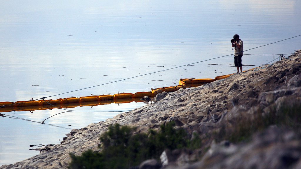 Un photographe immortalise la barrière flottante censée contenir le pétrole en fuite.