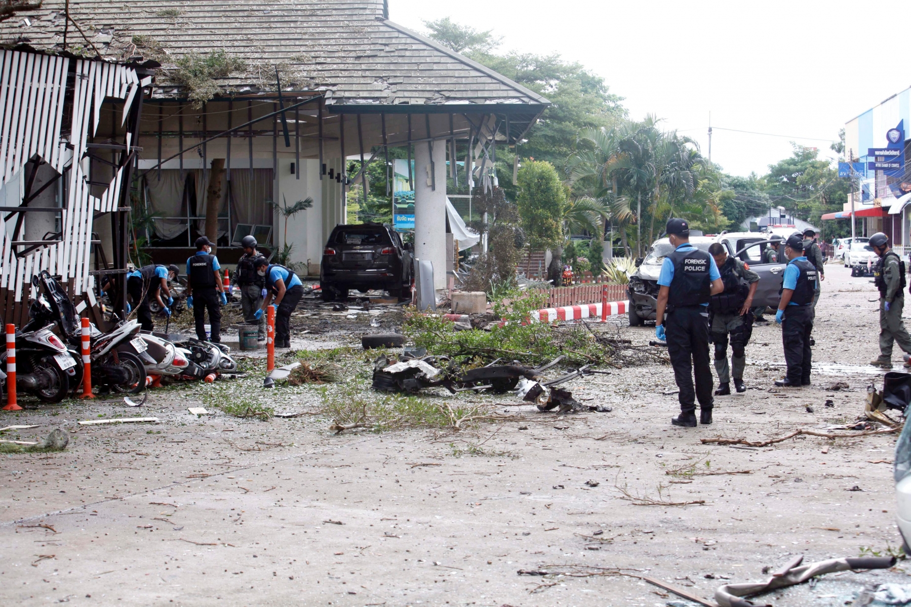epa05508101 Thai forensic police officers and members of Explosive Ordnance Disposal (EOD) unit inspect a blast scene after a car bomb attack at a hotel in Pattani, southern Thailand, 24 August 2016. A series of separate bomb attacks, including a bomb hidden in a truck, exploded at a car park of hotel,  killing one woman and wounding 29 people, media reports.  EPA/ABDULLAH WANGNI THAILAND BOMBING