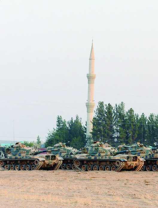 Turkish tanks stationed near the Syrian border, in Karkamis, Turkey, Saturday, Aug. 27, 2016. Turkey on Wednesday sent tanks across the border to help Syrian rebels retake the key Islamic State-held town of Jarablus and to contain the expansion of Syria's Kurds in an area bordering Turkey.(Ismail Coskun, IHA via AP) Turkey Syria