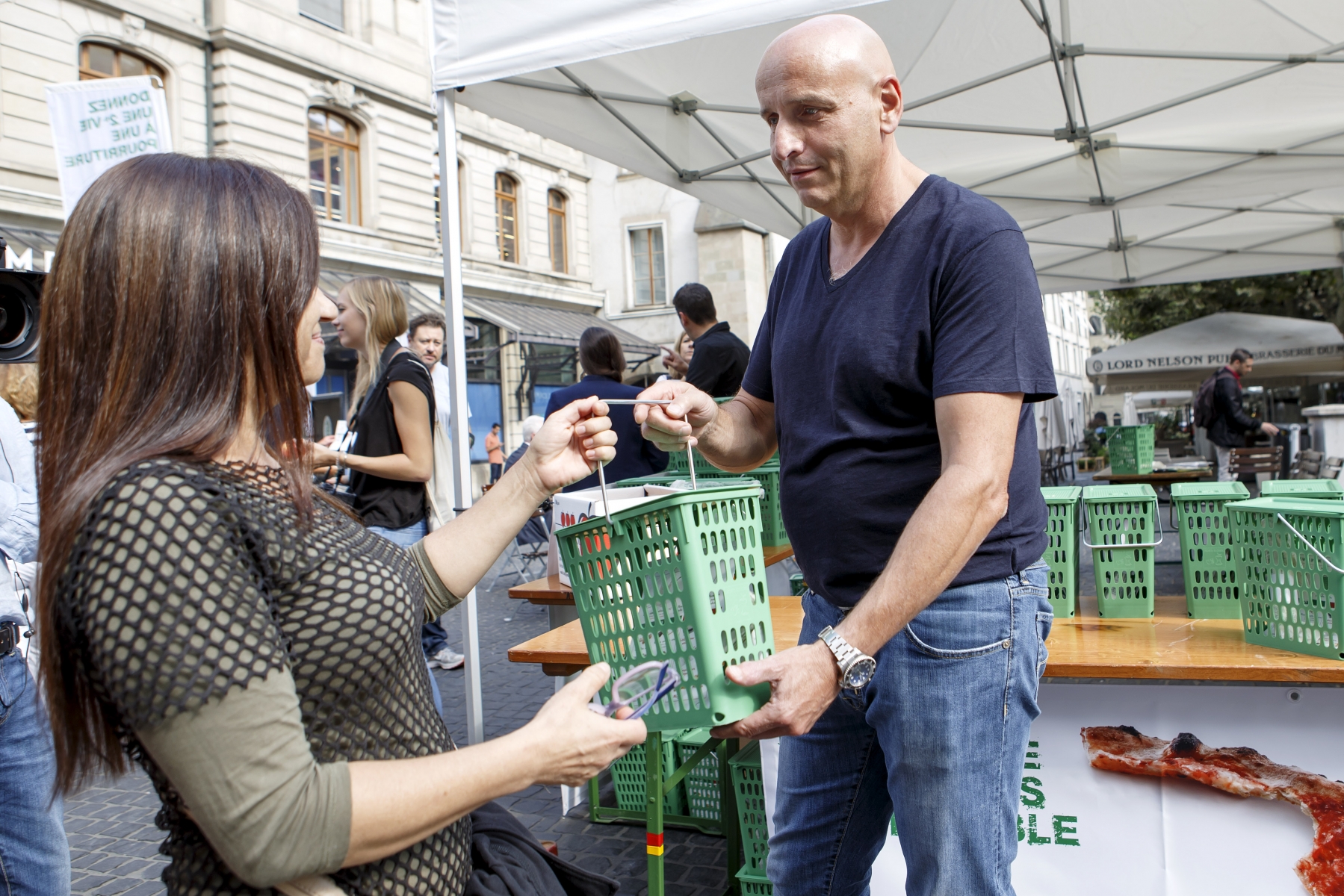 Philippe Chevrier, Chef étoilé et parrain de l'opération, donne une poubelle verte à une passante lors du lancement de la distribution de 100'000 "P'tites poubelles vertes". 
