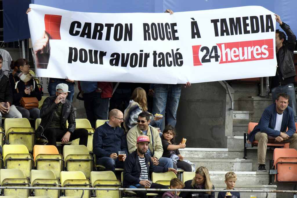 Des spectateurs brandissent une banderole "Carton rouge à Tamedia pour avoir taclé 24 Heures" lors du match Lausanne-Lugano.