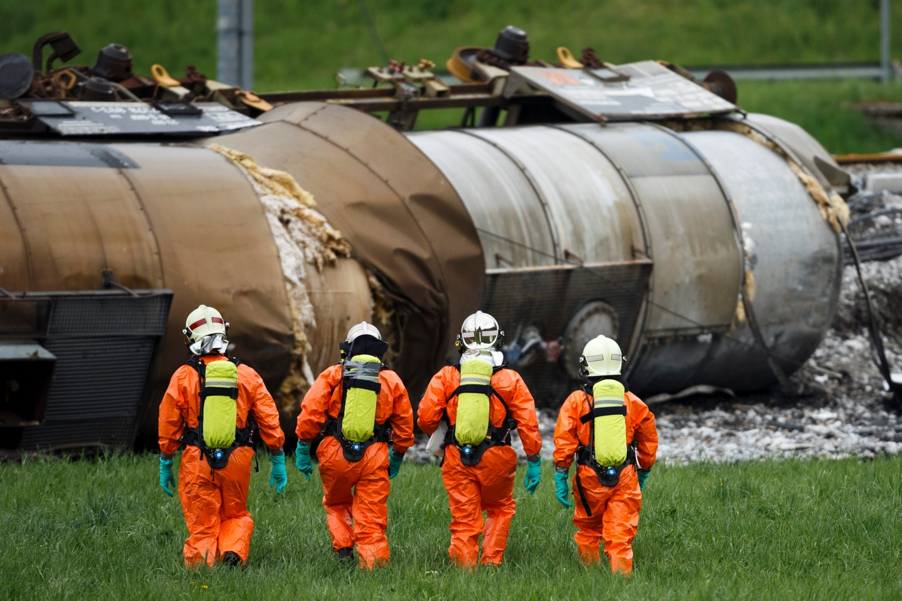 Des personnes en combinaison de protection chimique intervienent pres de wagons citerne couches suite au deraillement d'un convoi de marchandise CFF ce dimanche 26 avril 2015 a Daillens. Un train de marchandises a deraille samedi matin a 2h54 en gare de Daillens. Sans faire de blesses, le deraillement du convoi transportant des marchandises dangereuses necesitera pusieurs jours pour retablir integralement le trafic feroviaire. (KEYSTONE/Valentin Flauraud) SCHWEIZ BAHN SBB UNFALL