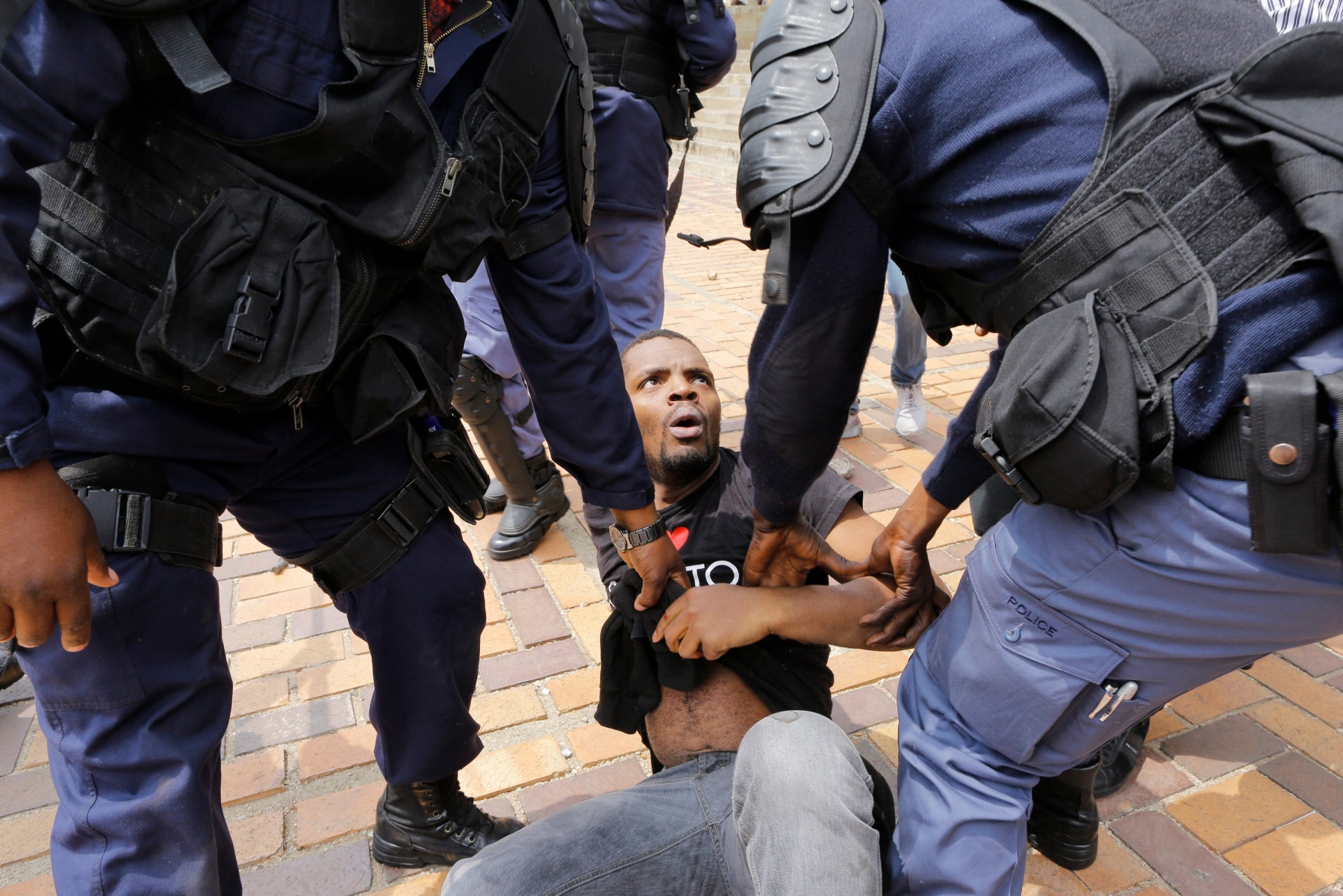 epa05569747 Police forces attempt to arrest a student leader as ongoing protests continue against the cost of higher education at the University of the Witwatersrand in Johannesburg, South Africa, 04 October 2016. Fees protests continued at universities across the country with private security companies being employed to keep order. Some eight students have been arrested this week by South African Police Services. The ministry of education announced a 8% increase of university fees following calls by student demonstrators of a 0% increase.  EPA/KIM LUDBROOK SOUTH AFRICA STUDENT PROTEST