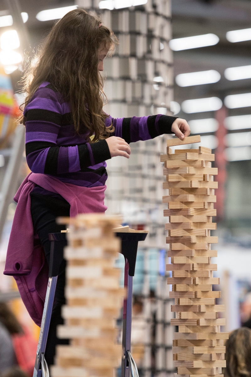 Ein Maedchen baut einen Turm aus Holzkloetzen an der Spielzeugmesse Suisse Toy, am Donnerstag, 6. Oktober 2016, in Bern. Die Suisse Toy ist der groesste Schweizer Branchenevent mit den neusten Spielen, Games, Bastelideen und Cosplay-Trends. (KEYSTONE/Peter Schneider) SCHWEIZ SUISSE TOY