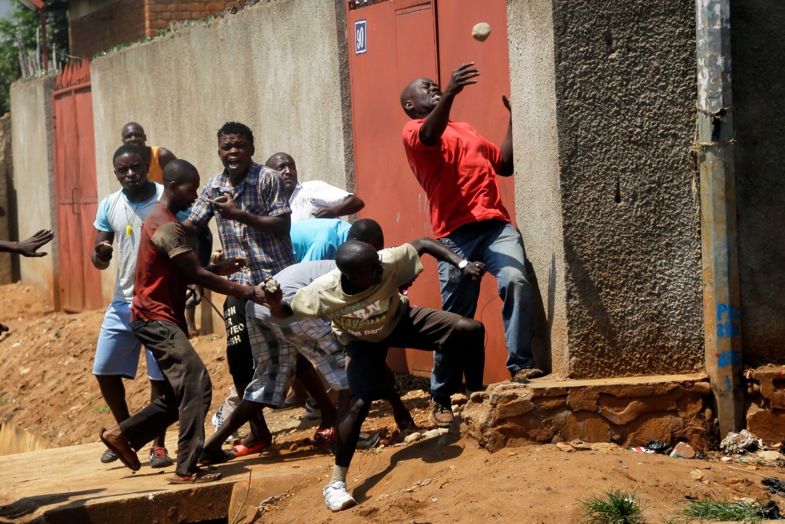 Protester throw stones at police during clashes in the Nyakabyga neighborhood of Bujumbura, Burundi, Thursday May 21, 2015. Protests continue against the  President's decision to seek a third term.  ( AP Photo/Jerome Delay)    APTOPIX Burundi Political Tensions