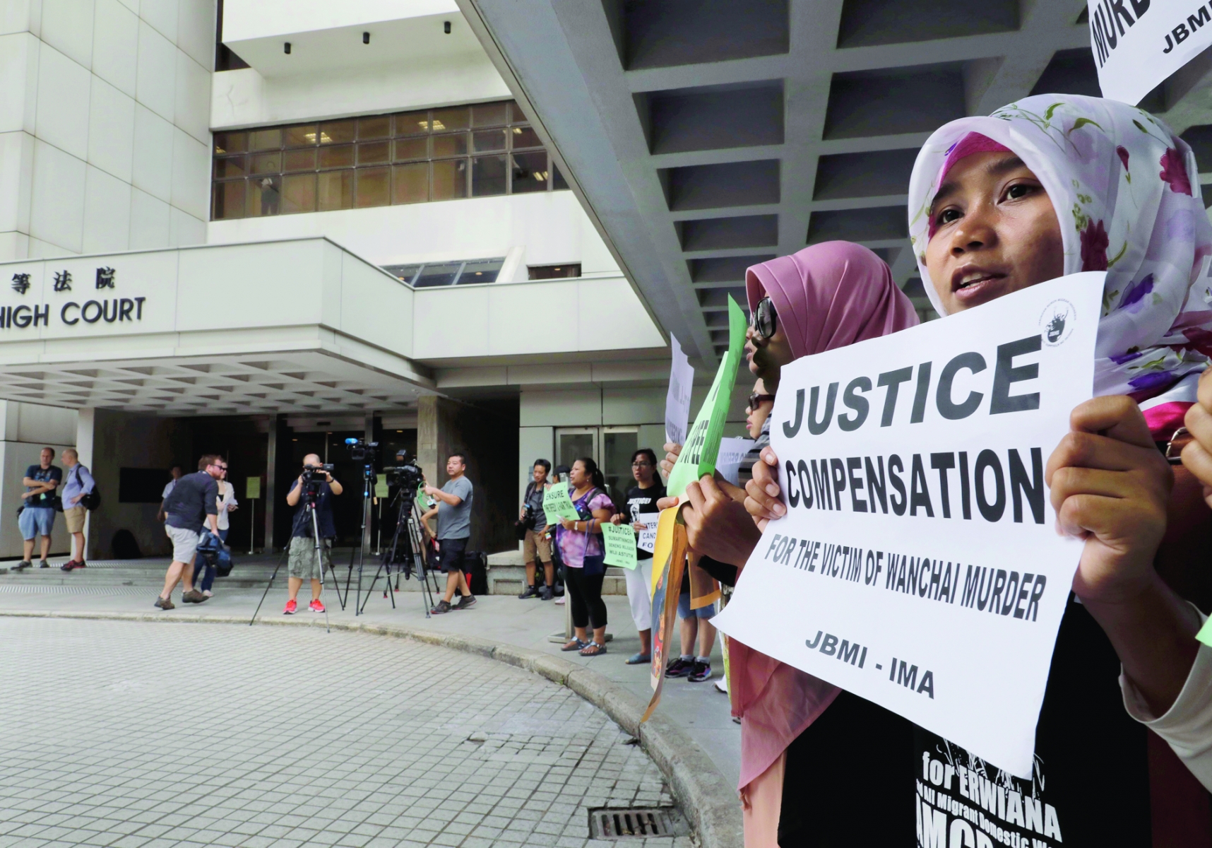 A migrant workers alliance group holds placards to protest the killings of two Indonesian women in 2014 outside the High Court in Hong Kong, Monday, Oct. 24, 2016. British banker Rurik Jutting accused of the grisly 2014 killings pleaded not guilty when he went on trial Monday, in a case expected to highlight the Asian financial hub's inequality and privileged lifestyle of its wealthy expat elite. (AP Photo/Vincent Yu) Hong Kong British Banker Murder Trial