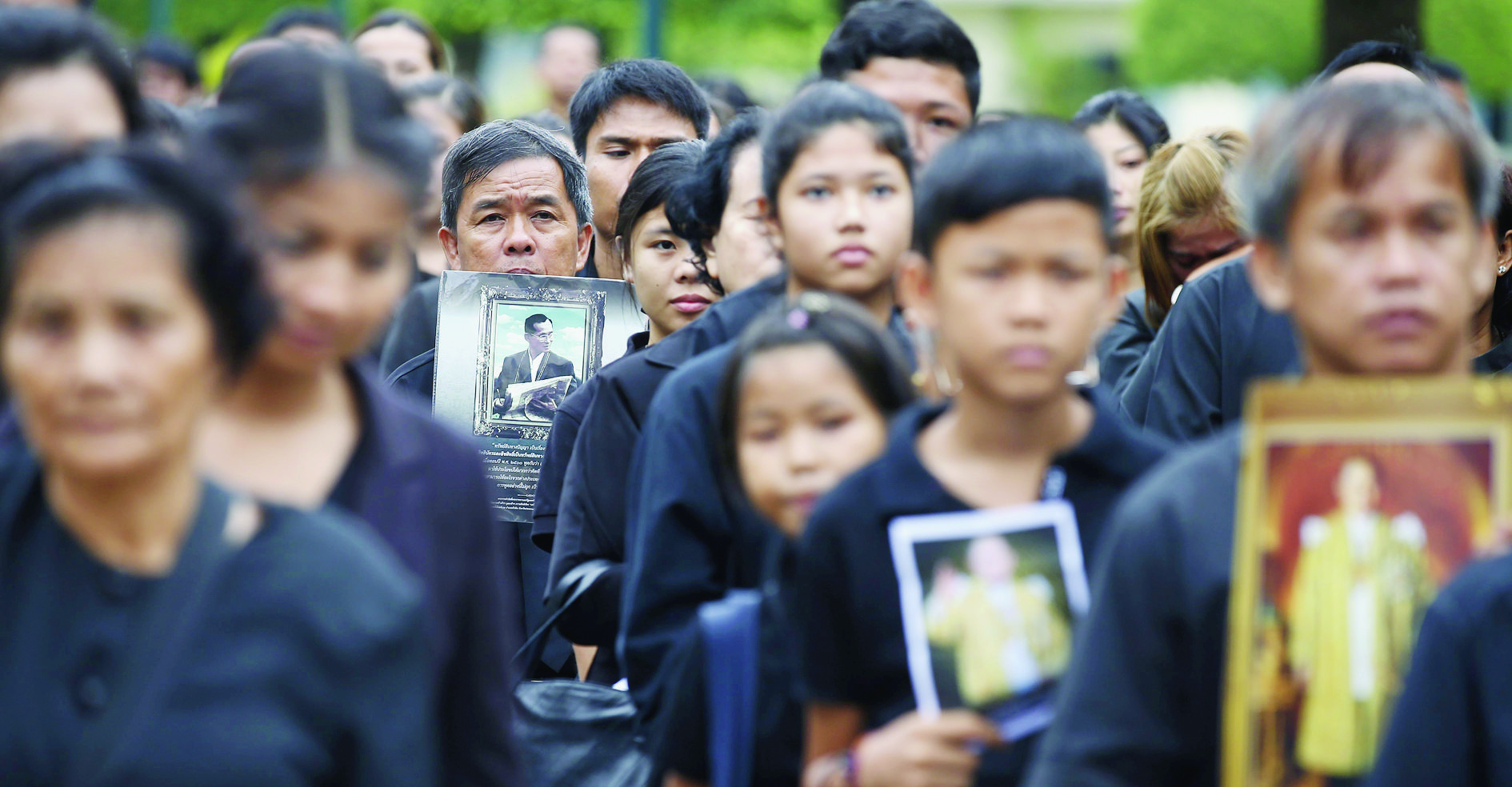 epaselect epa05607922 Thai mourners hold portraits of late Thai King Bhumibol Adulyadej as they queue up to pay obeisance to the Royal Urn of the late monarch, inside the Dusit Maha Prasat Throne Hall, at the Grand Palace in Bangkok, Thailand, 29 October 2016. King Bhumibol, the world's longest reigning monarch, died at the age of 88 in Siriraj Hospital in Bangkok on 13 October 2016.  EPA/NARONG SANGNAK epaselect THAILAND ROYALTY KING MOURNING