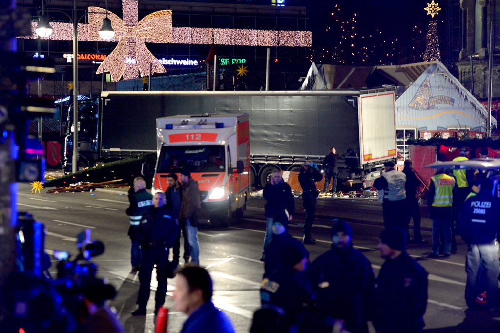 epa05682848 Police and rescue workers gather next to a truck at the scene after it crashed into a Christmas market, close to the Kaiser Wilhelm memorial church in Berlin, Germany, 19 December 2016. According to the police, several people are reported killed and many injured in what police suspect it was a deliberate attack.  EPA/MAURIZIO GAMBARINI