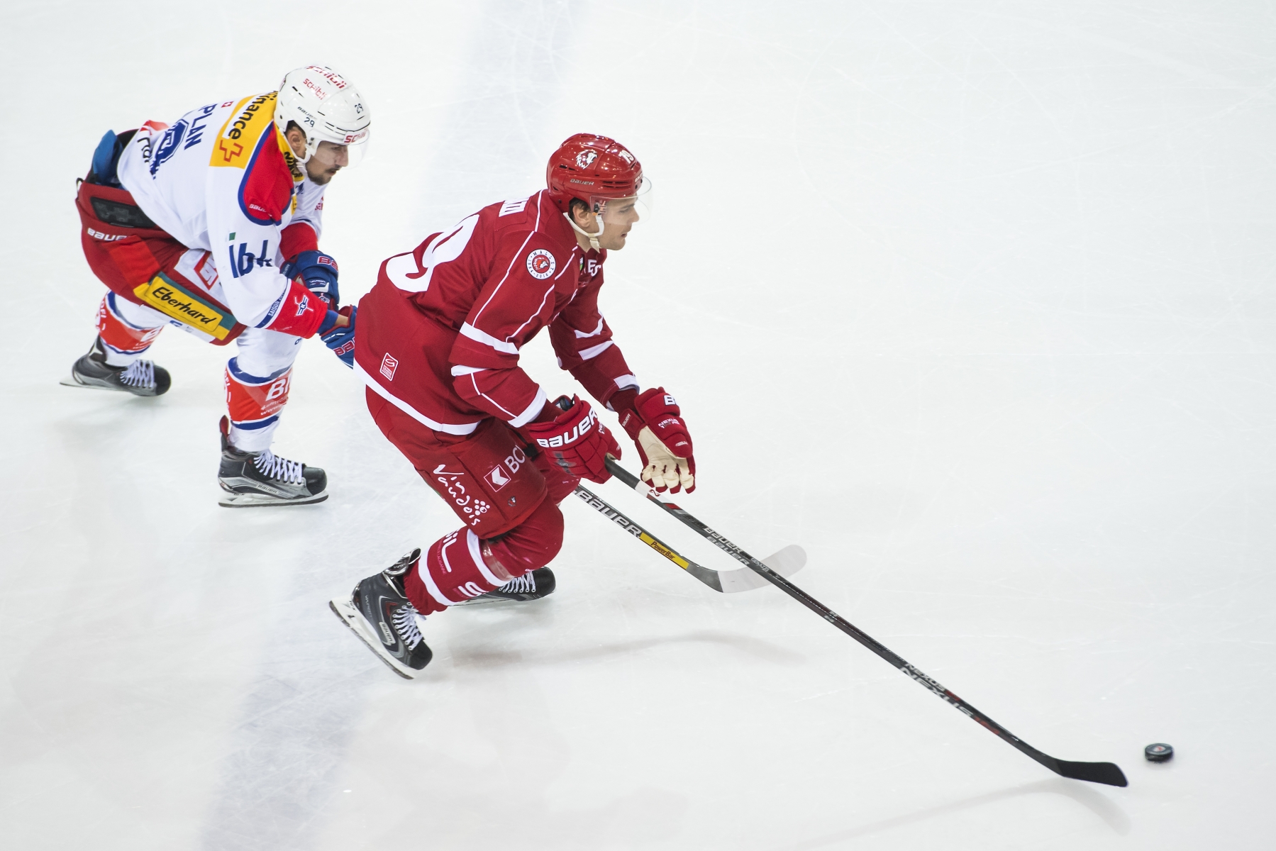 LÕattaquant de Kloten Vincent Praplan, gauche, lutte pour le puck avec le defenseur lausannois Joel Genazzi, droite, lors du match du championnat suisse de hockey sur glace de National League A, entre le Lausanne Hockey Club, LHC, et le EHC Kloten ce vendredi 25 novembre 2016 a la patinoire de Malley a Lausanne. (KEYSTONE/Jean-Christophe Bott)