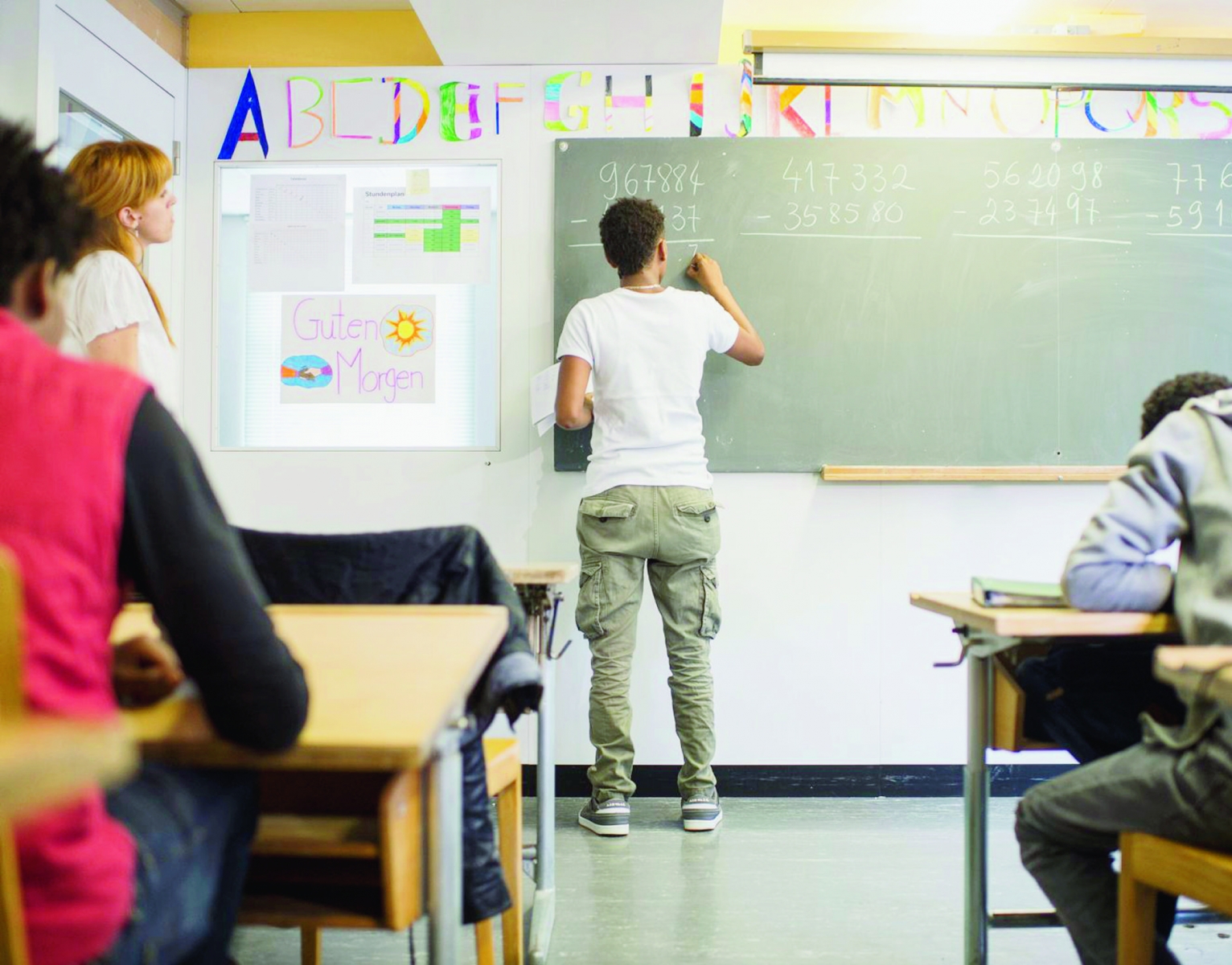 ARCHIV --- ZU DEN EMPFEHLUNGEN DER SODK ZU UNBEGLEITETEN MINDERJAEHRIGEN IM ASYLBEREICH STELLEN WIR IHNEN FOLGENDES BILD ZUR VERFUEGUNG --- Lehrerin Silva, links, beobachtet ihren Schueler Samuel, Mitte, im Schulunterricht anlaesslich einer Medienkonferenz der Peregrina-Stiftung, einer Stiftung fuer die Unterbrinung und Betreuung der Asylsuchenden in den Durchgangsheimen des Kantons Thurgau, aufgenommen am Montag, 6. Juli 2015 in Weinfelden. Seit 2014 verzeichnet die Peregrina-Stiftung eine Zunahme von unbegleiteten minderjaehrigen Asylsuchenden, kurz "UMA". (KEYSTONE/Ennio Leanza) SCHWEIZ ASYLBEREICH MINDERJAEHRIGE