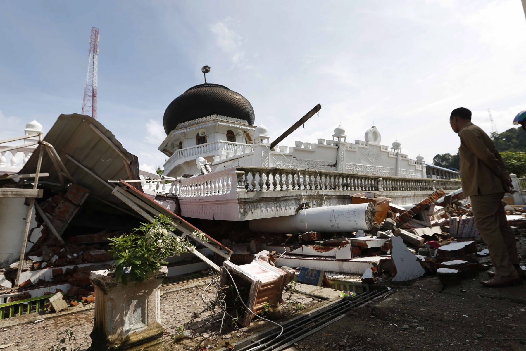 epa05663568 Local villagers observe a collapsed mosque that suffered damage during an earthquake in the Pidie Jaya district in Pidie Jaya, Aceh, Indonesia, 07 December 2016. According to media reports at least 52 people were killed after a strong quake rocked Aceh in the early morning of 07 December and damaged buildings. According to the United States Geological Survey (USGS), the shallow 6.5 magnitude earthquake struck Aceh province of Sumatra island. No tsunami alert was issued in the wake of the earthquake.  EPA/HOTLI SIMANJUNTAK INDONESIA EARTHQUAKE