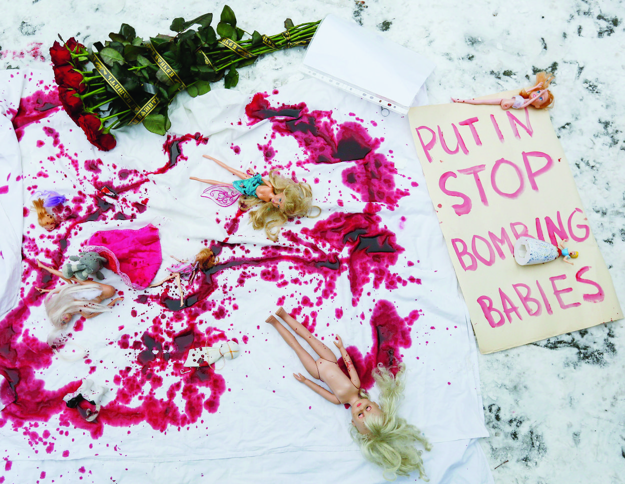 epa05676444 A banner with the text 'Putin stop bombing babies' is placed on the ground next to dolls and flowers during a demonstration of activists calling to stop the bombing of Aleppo in Syria, in front of the Russian embassy in Kiev, Ukraine, 15 December 2016. Activists gathered to show solidarity with trapped citizens of Aleppo in Syria and to demand to stop the bombing of Aleppo in Syria.  EPA/ROMAN PILIPEY UKRAINE PROTEST SYRIA ALEPPO