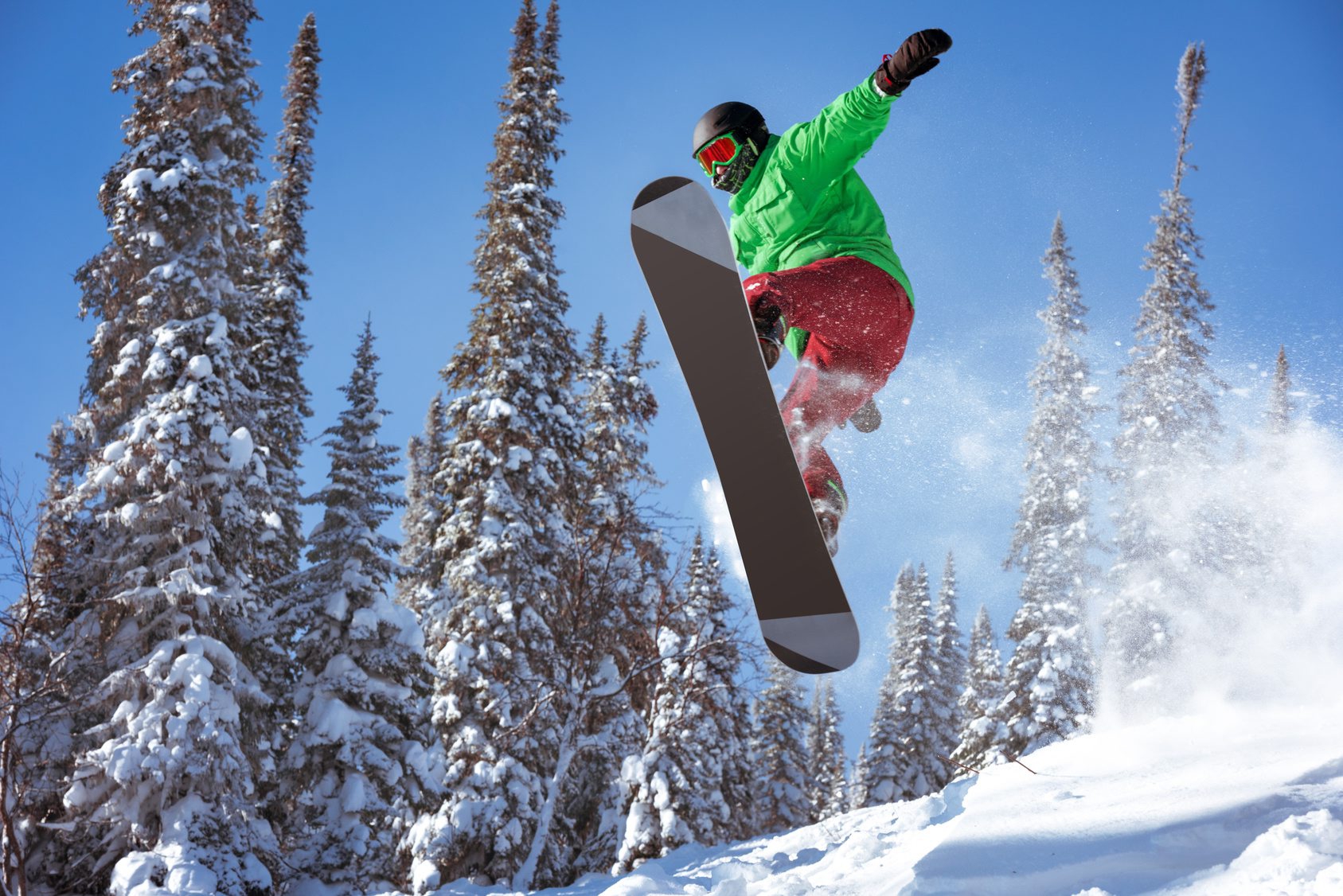 Snowboarder jumps in forest. Freeride snowboarding in Sheregesh ski resort Snowboarder jumps freeride powder forest