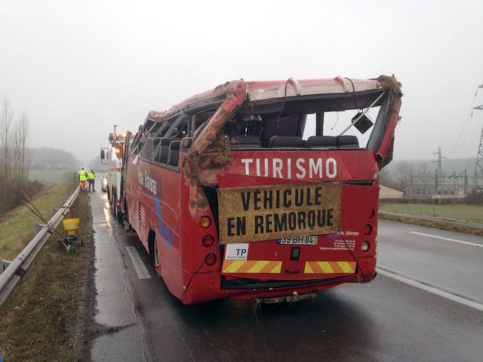 In this photo taken Sunday, Jan. 8, 2017, and provided by Creusot Infos, the wreckage of bus is towed away after it crashed off a highway near Charolles, central France, Sunday, Jan. 8, 2017. Four Portuguese tourists were killed and some 20 others injured today when their bus crashed off a highway in central France. (Creusot Infos via AP) FRANCE OUT France Bus Accident