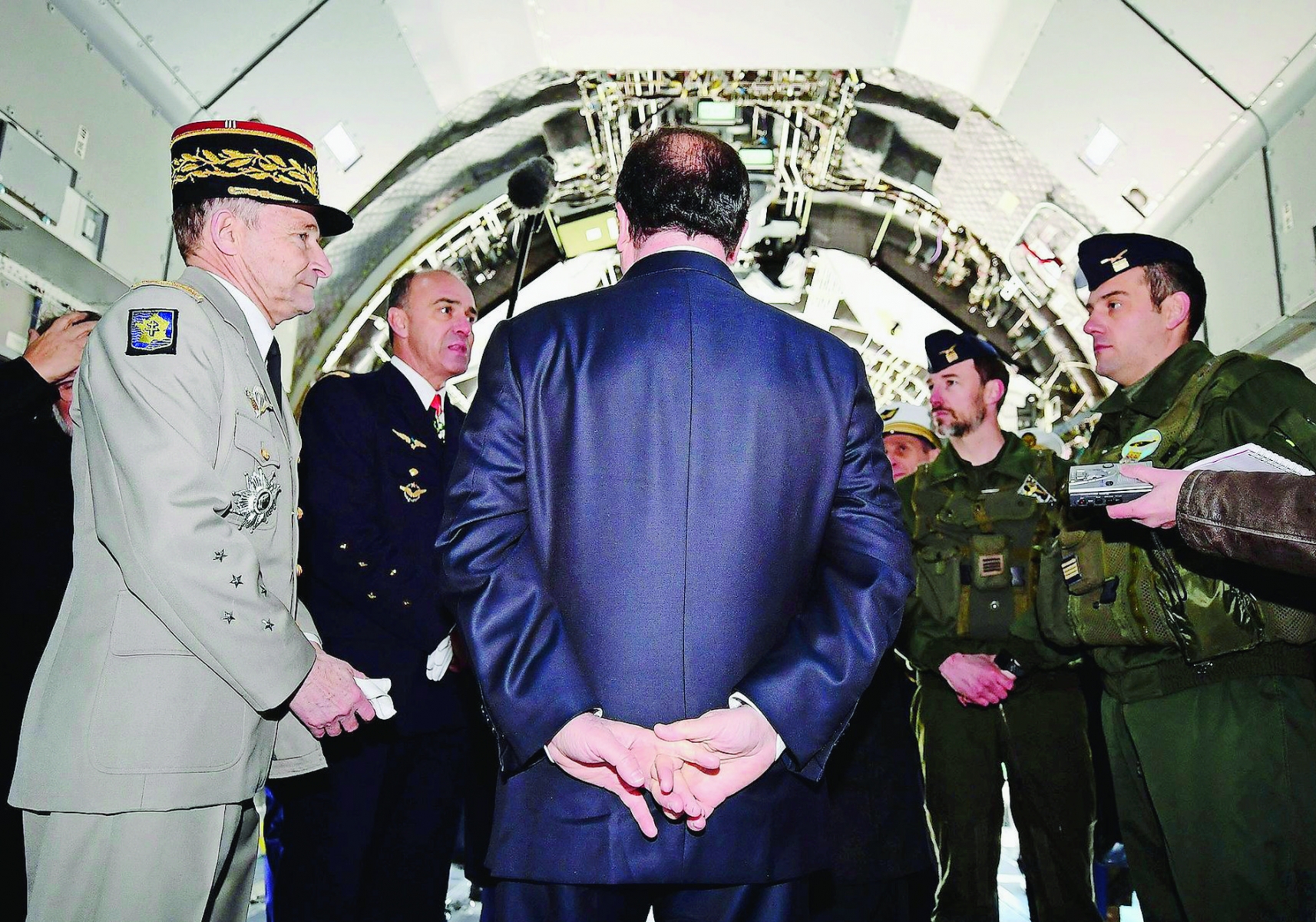 French President Francois Hollande, back to the camera, speaks to soldiers in an Airbus A400M as he visits the military airbase 118, in Mont-de-Marsan, southwestern France, where he gave his New Year address to the army, Friday Jan. 6, 2017. (Caroline Blumberg, Pool via AP) FRANCE HOLLANDE