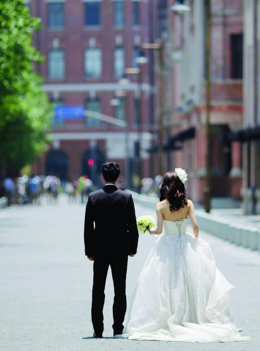 A newly wed couple waits for a wedding photo session Tuesday, May 29, 2012 in Shanghai, China. (AP Photo/Eugene Hoshiko) APTOPIX China Daily Life