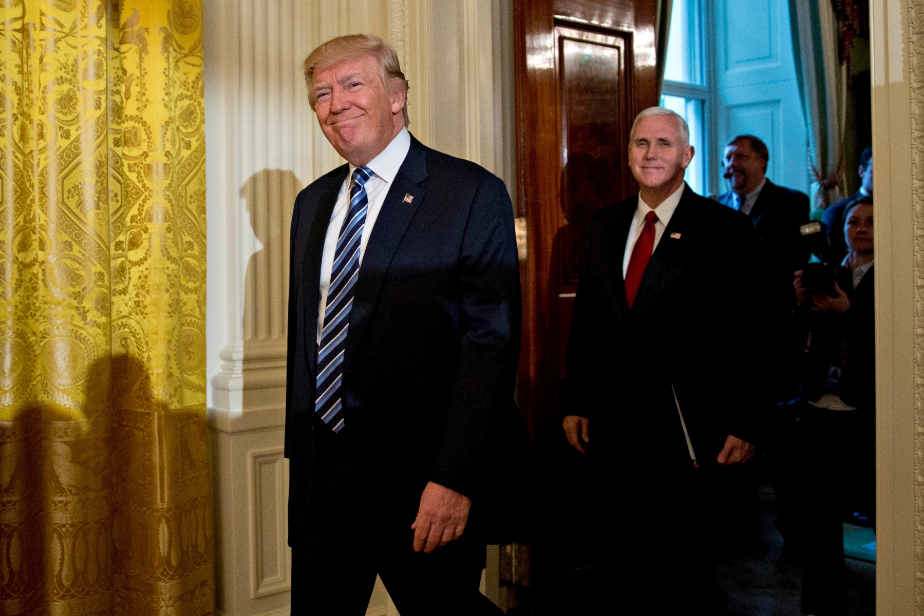 epa05742773 US President Donald Trump, left, and US Vice President Mike Pence arrive to a swearing in ceremony of White House senior staff in the East Room of the White House in Washington, DC, USA, on 22 January 2017.  EPA/Andrew Harrer / POOL USA TRUMP EAST ROOM