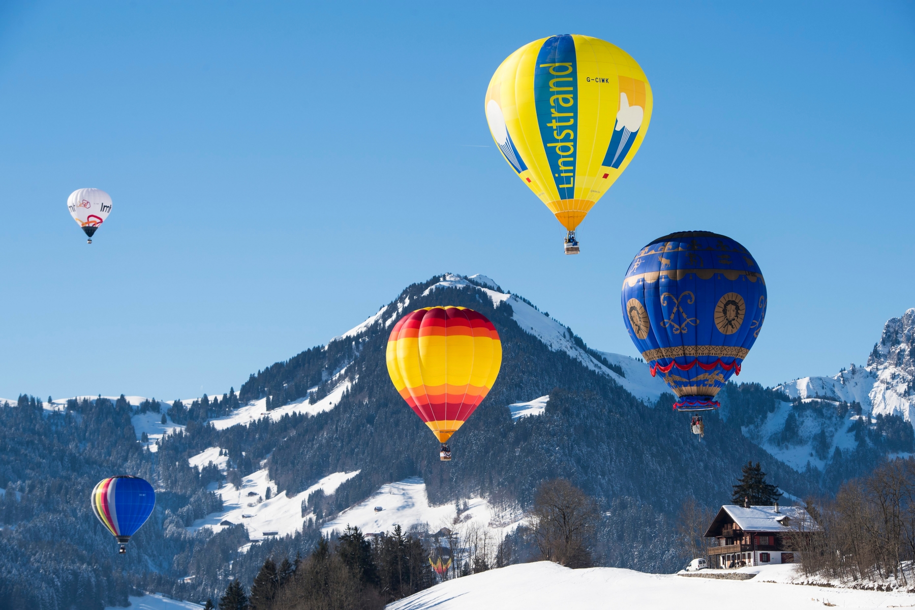Hot air balloons fly during the 39th International Hot Air Balloon Week in Chateau-d'Oex, Switzerland, Saturday, January 21, 2017. More than 50 balloons and 70 pilots from 15 countries take part in the event between 21 and 29 January in the Swiss mountain resort. (KEYSTONE/Jean-Christophe Bott) SWITZERLAND HOT AIR BALLOONS FESTIVAL
