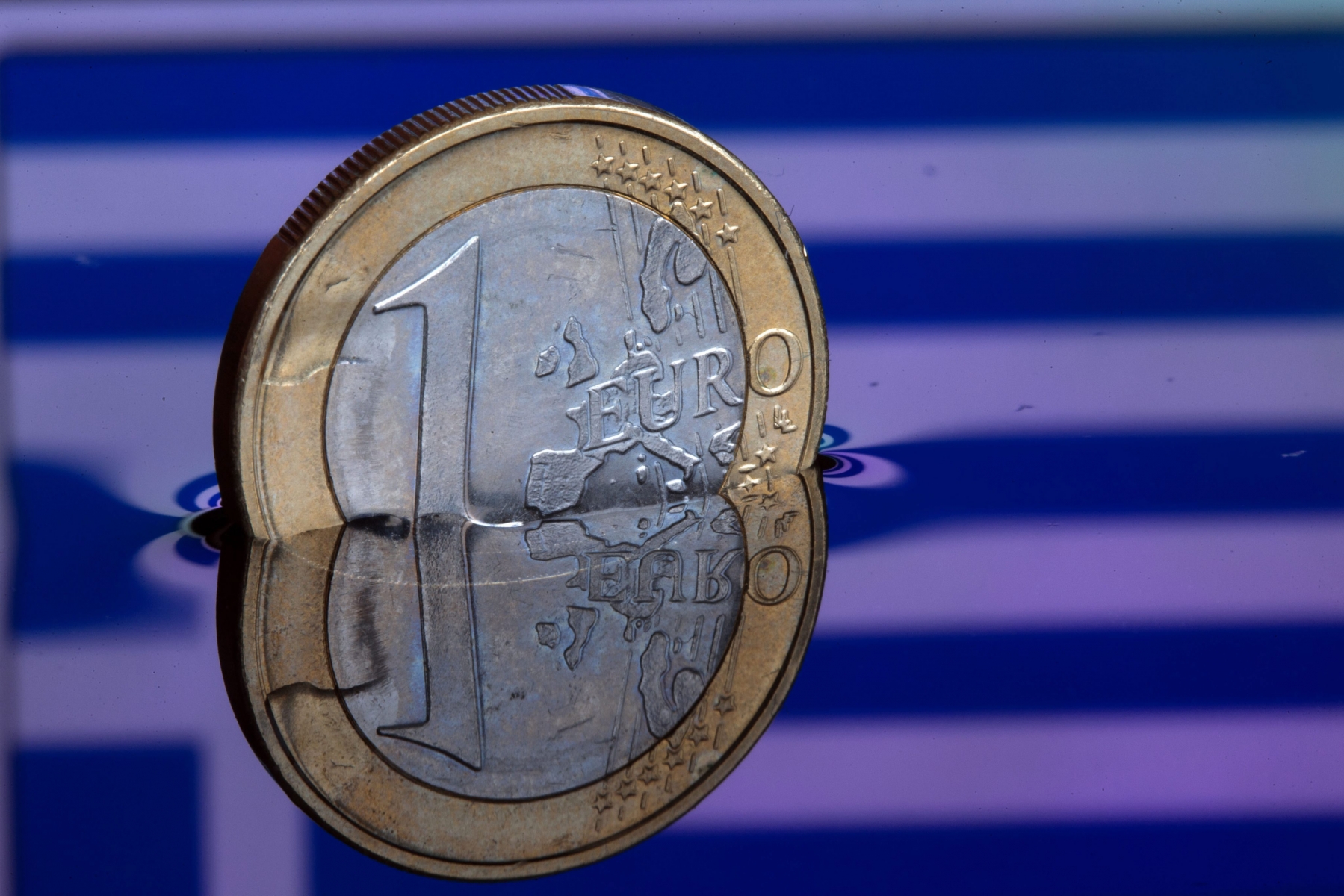 epa04547273 An illustration picture shows a one euro coin in water, which reflects the Greek flag, in Schwerin, Germany, 05 January 2015. The situation in Greece and the monetary policy of the ECB have caused the commom currency euro to drop to its lowest rate since 2006.  EPA/JENS BUETTNER GERMANY GREECE EURO