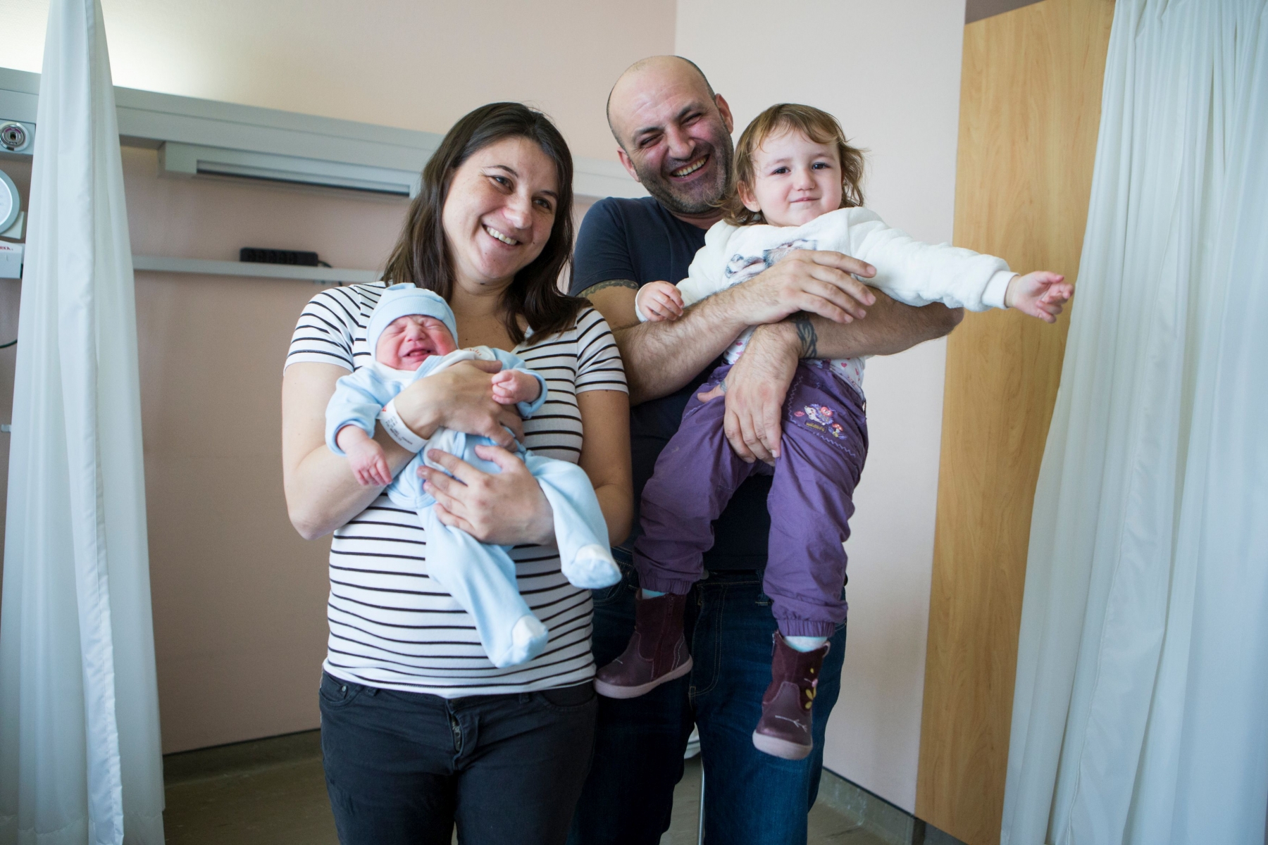 La famille Ozcan au complet. De g. à dr. Nalan, la maman, avec le petit Elias dans ses bras. Ela Maelys, la grande de 20 mois,  est ravie d'être portée par son papa, Mustafa.