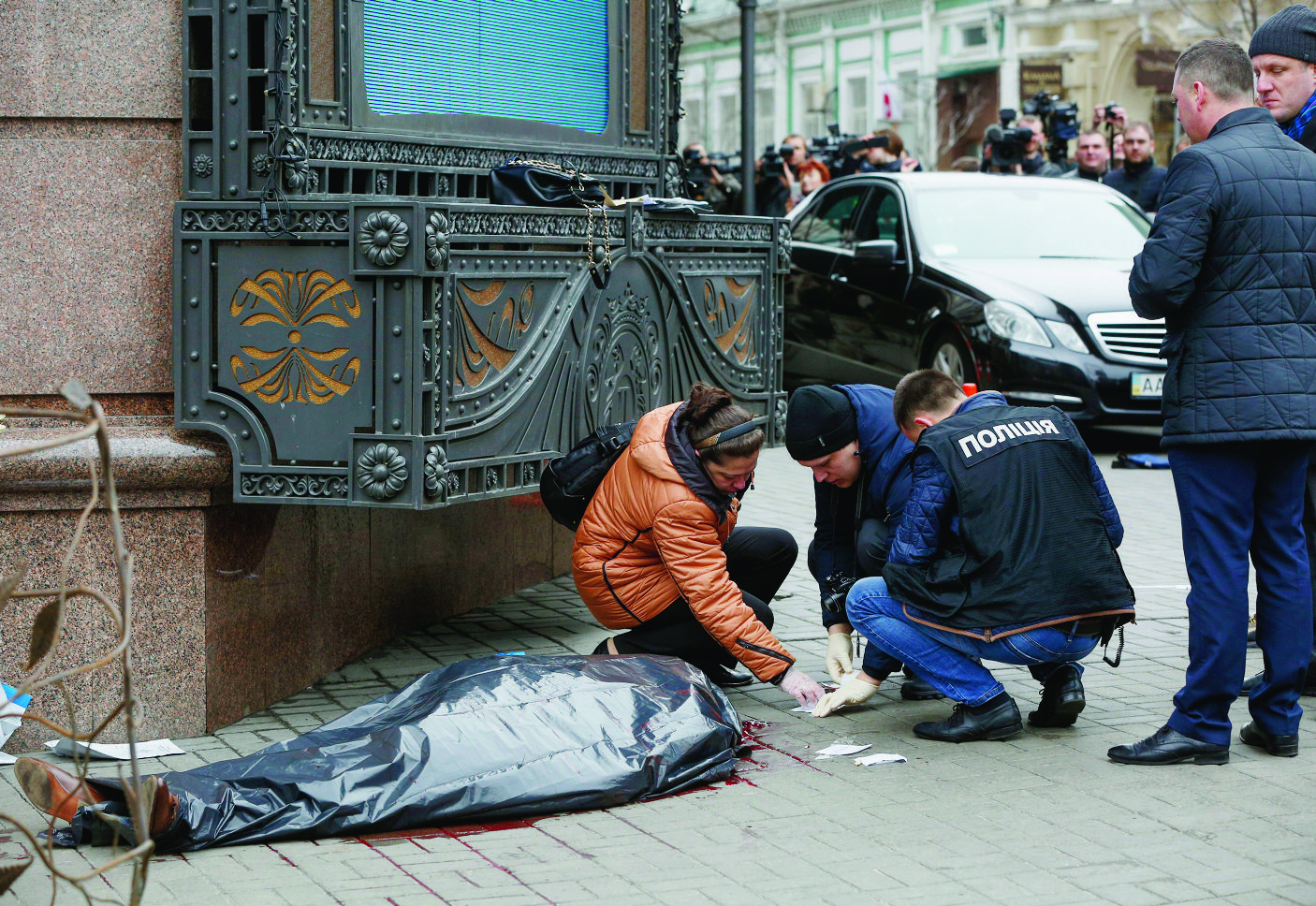 Forensic experts and police officers examine the scene following the killing of Denis Voronenkov in Kiev, Ukraine, Thursday, March 23, 2017. Ukrainian police said Voronenkov was shot dead Thursday by an unidentified gunman at the entrance of an upscale hotel in the Ukrainian capital. Voronenkov, 45, a former member of the communist faction in the lower house of Russian parliament, had moved to Ukraine last fall and had been granted Ukrainian citizenship. (AP Photo/Sergei Chuzavkov) Ukraine Killing