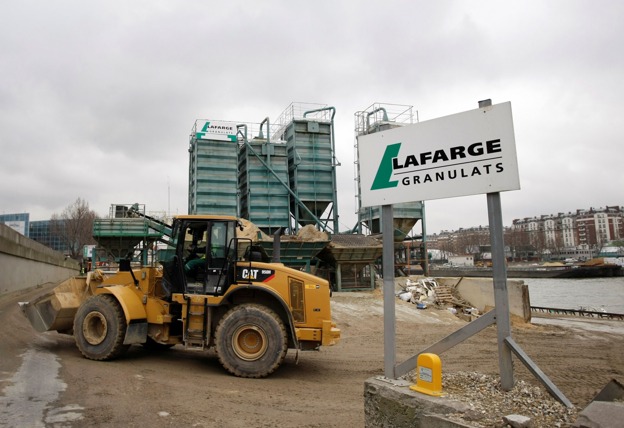 A Caterpillar drives at a French construction materials group Lafarge site in Paris, Wednesday Feb.18, 2009. Lafarge is a cement, plaster and concrete company.(AP Photo/Thibault Camus) FRANKREICH LAFARGE