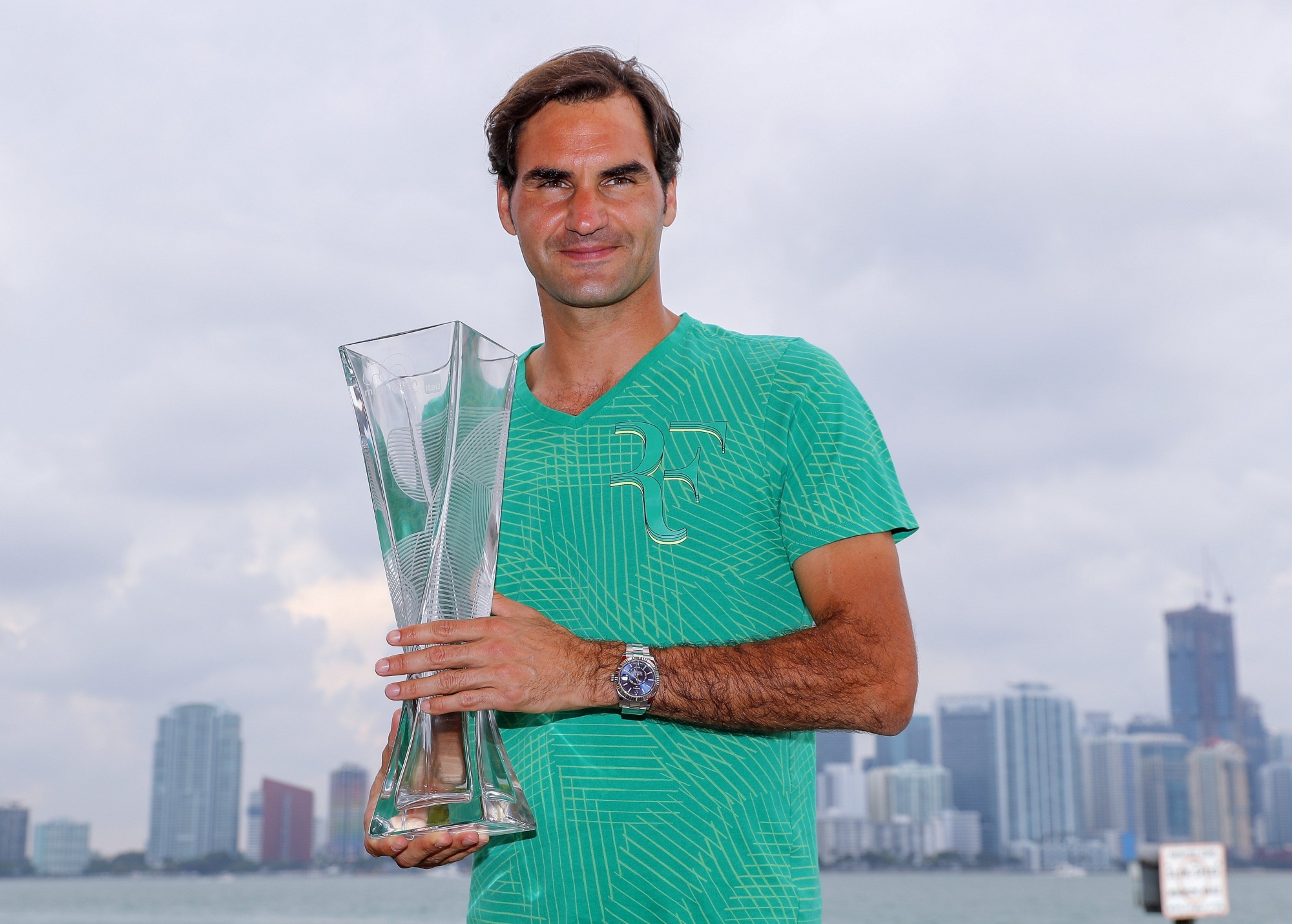 epa05885186 Roger Federer of Switzerland poses with the winner's trophy, with the downtown Miami skyline behind him, after defeating Rafael Nadal of Spain during the men's singles final match at the Miami Open tennis tournament on Key Biscayne, Miami, Florida, USA, 02 April 2017.  EPA/ERIK S. LESSER