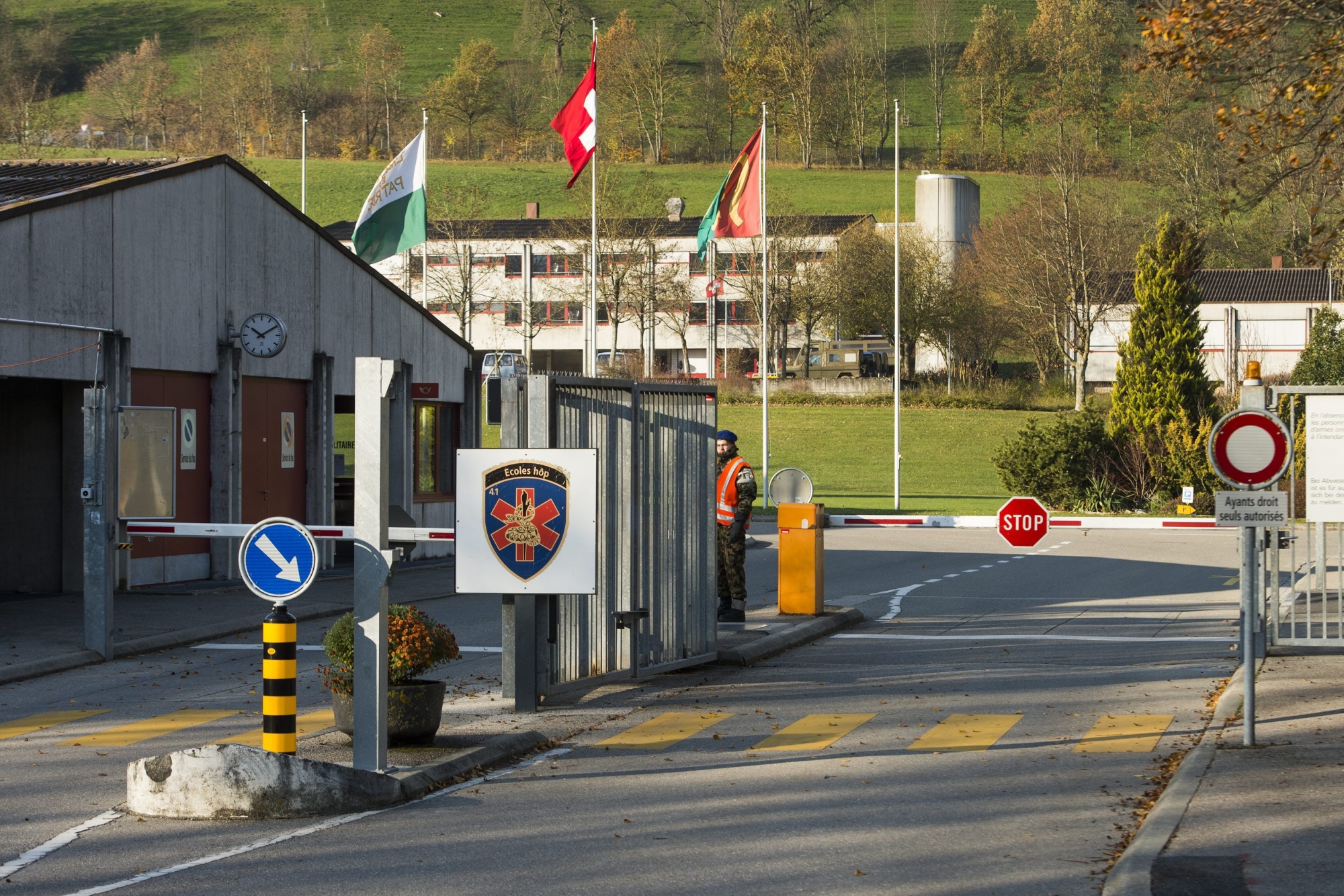 Un militaire garde l'entree de la caserne militaire de Moudon ce mardi 26 novembre 2013 a Moudon dans le canton de Vaud. En Suisse romande, les places de Moudon (VD), Savatan (VS), St-Maurice (VS), la Poya (FR) et les Vernets (GE) fermeront a annonce le Conseiller federal Ueli Maurer ce matin. (KEYSTONE/Jean-Christophe Bott) SCHWEIZ MILITAER KASERNE MOUDON