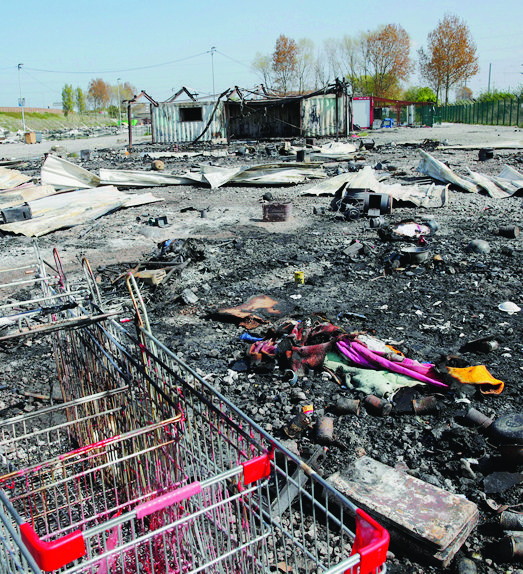 Burned remains of a migrant camp in the Dunkirk suburb of Grande-Synthe, northern France, Tuesday, April 11, 2017. Several hundred migrants have disappeared after they were evacuated from a camp in northern France that was ravaged by a shocking fire that left 10 injured, according to authorities and aid workers trying to ensure alternative shelter and calm tensions. (AP Photo/Christophe Ena) France Migrant Camp Fire