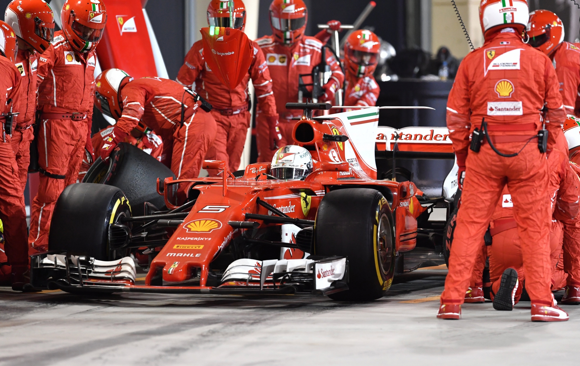 epa05911210 Pit crew and mechanics surround Ferrari's German driver Sebastian Vettel in the pit lane during the Bahrain Formula One Grand Prix at the Sakhir circuit near Manama, Bahrain, 16 April 2017.  EPA/ANDREJ ISAKOVIC / AFP POOL AFP POOL POOL POOL
