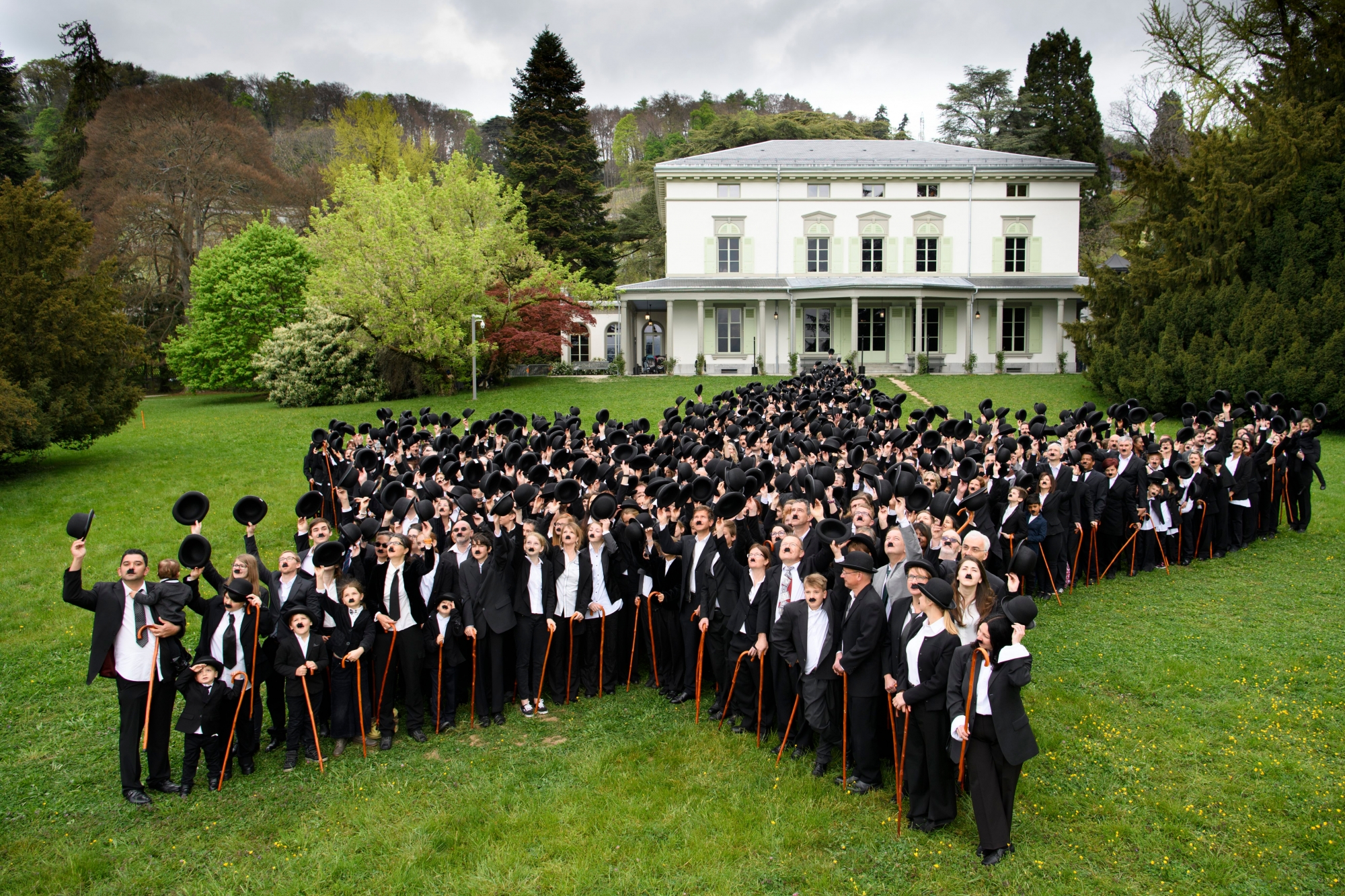 662 peoples dressed in Charlie Chaplin pose for a group photo in front of the Manoir de Ban during an attempt of the world's largest gathering of people dressed as The Tramp on the occasion of Charlie Chaplin's birthday, and to celebrate the first year of the museum "Chaplin's World by Grevin", in Corsier, above Vevey, Switzerland, Sunday, April 16, 2017. Chaplin's World, a museum on English comic actor, filmmaker, and composer Charlie Chaplin, is located in a 14 hectare park of lush trees, it occupies the mansion where the Chaplin family lived the last 25 years of Charly Chaplin's life. (KEYSTONE/Laurent Gillieron) SWITZERALND WORLD RECORD MUSEUM CHARLIE CHAPLIN