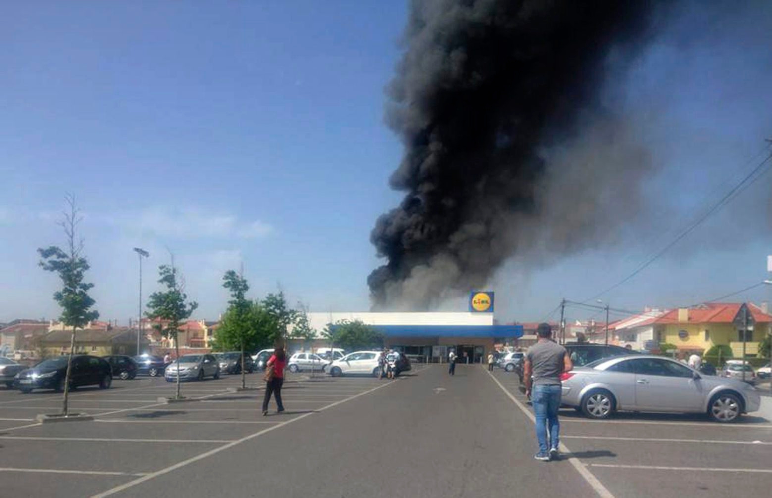 Smoke rises next to a supermarket after a small plane crashed in Tires, near Lisbon, Portugal, Monday, April 17, 2017. Portuguese officials say a small plane has crashed beside a supermarket near Lisbon, killing four people on board the aircraft and one on the ground (Fabio Miguel Pocarico via AP) Portugal Small Plane Crash