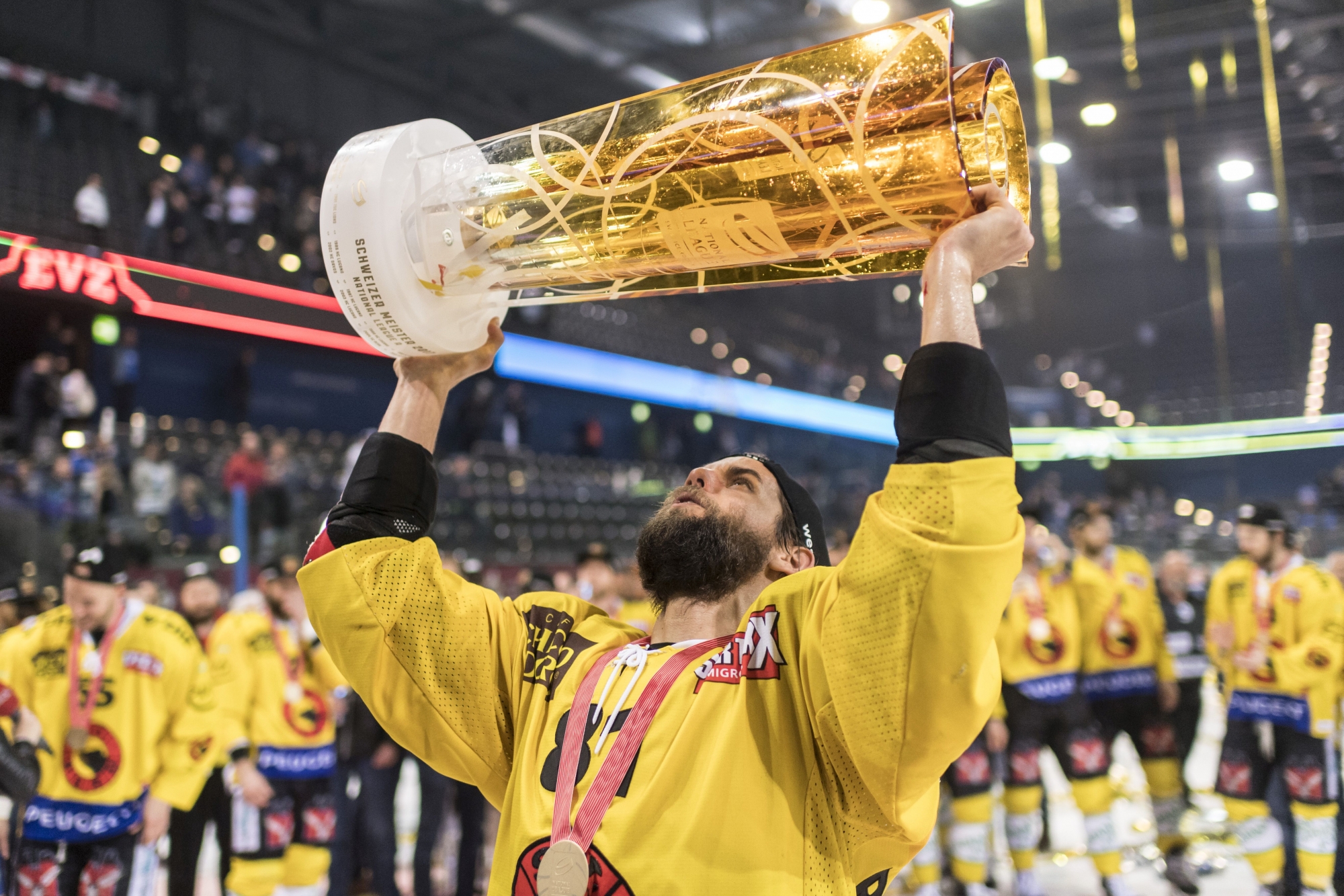 Der Berner Thomas Ruefenacht stemmt den Meisterpokal und feiert mit seiner Mannschaft als Eishockey Schweizermeister nach dem sechsten Eishockey Playoff-Finalspiel der National League A zwischen dem EV Zug und dem SC Bern, am Montag, 17. April 2017 in der Bossard Arena in Zug. (KEYSTONE/Ennio Leanza)