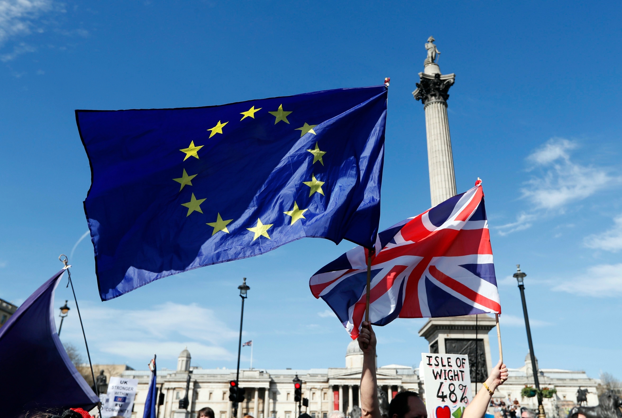 The European flag and the United Jack flag are held by Anti Brexit campaigners walking past Nelson's Column in Trafalgar Square towards Britain's parliament in London, Saturday March 25, 2017. Britain's Prime Minister Theresa May is expected to start the process of leaving the European Union on Wednesday March 29. (AP Photo/Kirsty Wigglesworth) Britain Brexit