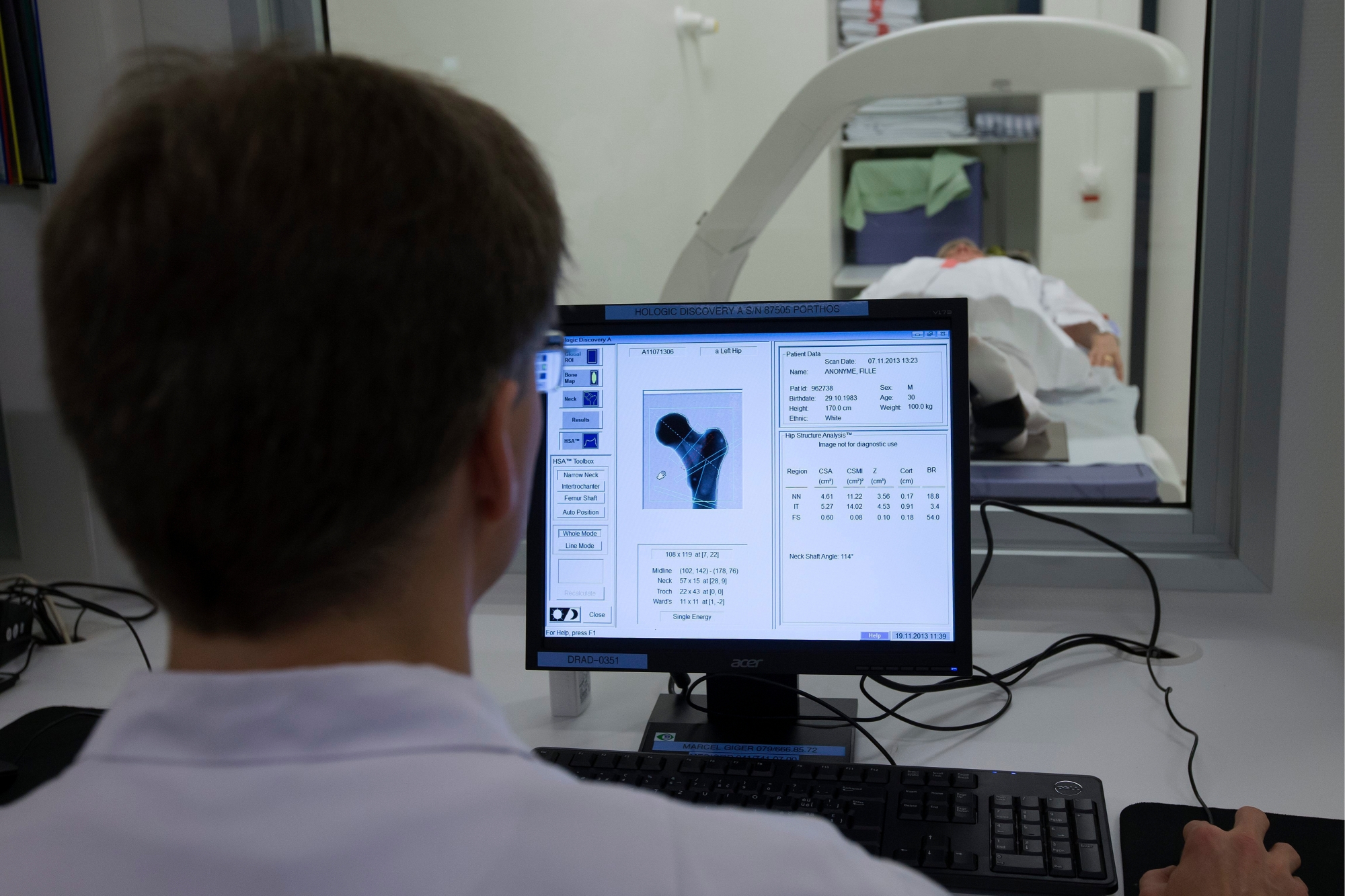 Un technicien en radiologie medicale des HUG fait une demostration du scanner peripherique a tres haute resolution installe dans laboratoire de mesure de la densite minerale osseuse des HUG (Hopitaux Universitaires de Geneve), lors d'une visite du laboratoire, ce mardi 19 novembre 2013 a Geneve. Les Hopitaux universitaires de Geneve, HUG, ont decide d'ameliorer leur dispositif de diagnostic de l'osteoporose en installant deux nouveaux osteodensitometres, scanner peripherique a tres haute resolution. (KEYSTONE/Salvatore Di Nolfi) SCHWEIZ SPITAL GENF LABOR MINERALOMETRIE