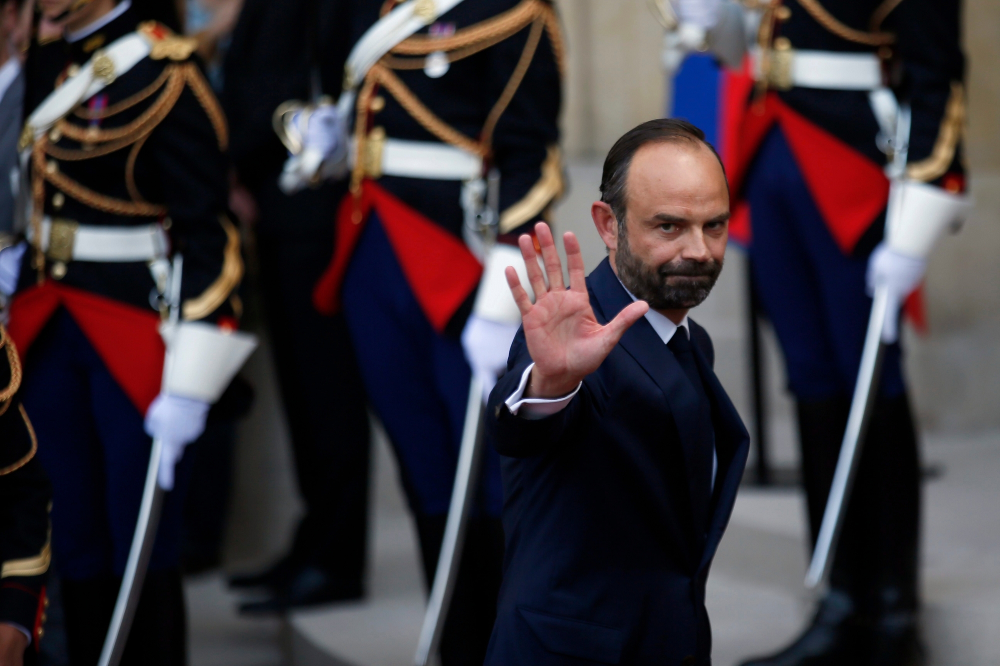 Newly appointed French Prime Minister Edouard Philippe waves after the handover ceremony with outgoing Prime Minister Bernard Cazeneuve in Paris, Monday, May, 15, 2017. French President Emmanuel Macron has appointed Philippe, a relatively unknown 46-year-old lawmaker, as prime minister, making good on campaign promises to repopulate French politics with new faces. (AP Photo/Francois Mori) France President