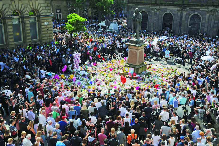 People attend a one minute silence to the victims of Monday's explosion at St Ann's Square in Manchester, England Thursday May 25 2017.  More than 20 people were killed in an explosion following a Ariana Grande concert at the Manchester Arena late Monday evening . (AP Photo/Rui Vieira) Britain Concert Blast
