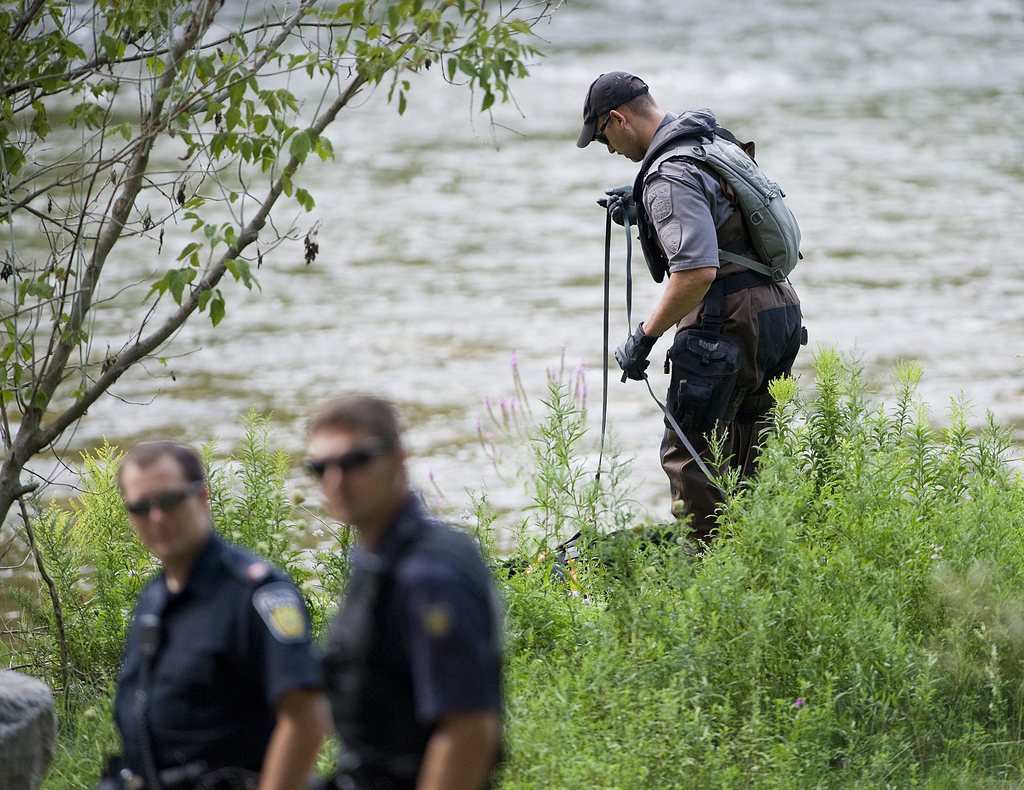 La police poursuit les recherches dans la rivière.