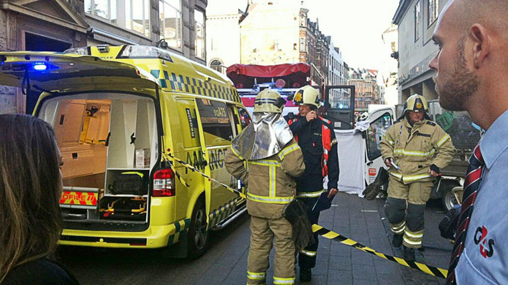 Des pompiers sur le lieu de l'accident curieux dans les rues de Copenhague.