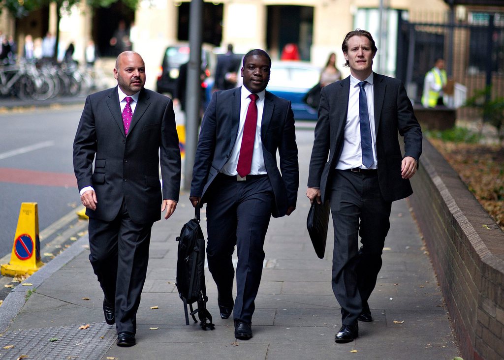 epa03392199 Kweku Adoboli (C) and his lawyers arrive at the Sothwark Crown Cort where he stands trial on charges of fraud by abuse of position and false accounting, London, Britain, 10 September 2012. Adoboli is accused of undertaking unauthorised trading at Swiss bank UBS that resulted in a $2bn loss for the bank, one of the biggest ever cases of alleged unauthorised trading.  EPA/BOGDAN MARAN