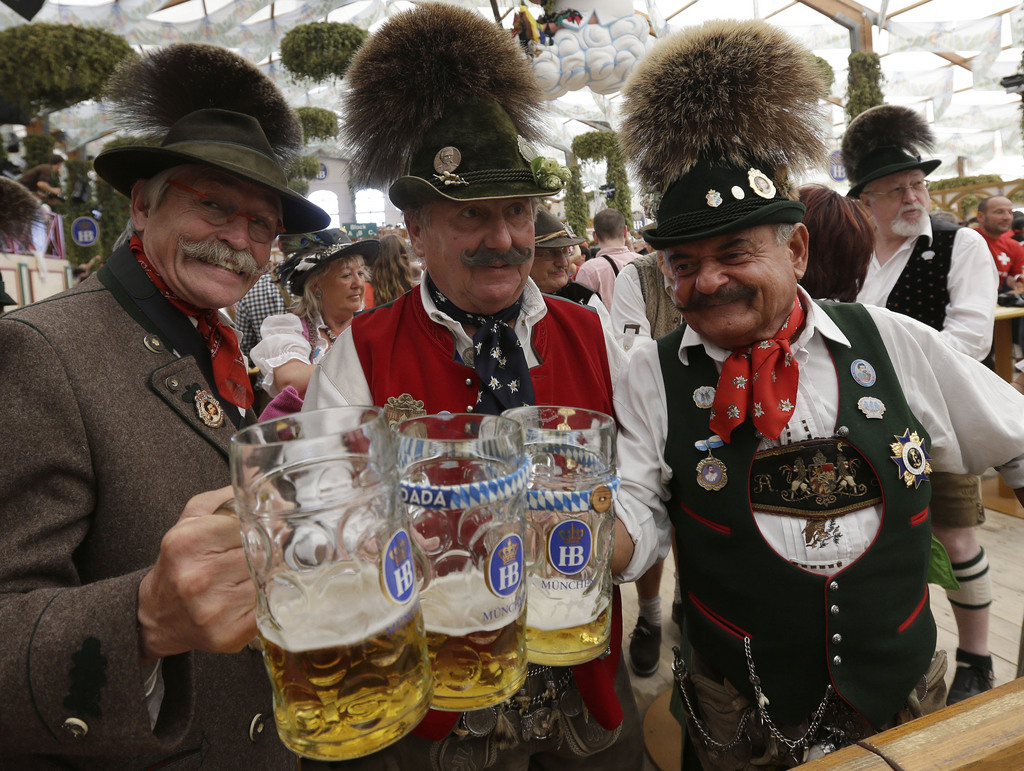 Traditionally dressed Bavarian men salute and enjoy a sunny day of the famous Bavarian "Oktoberfest" beer festival in Munich, southern Germany, Tuesday, Sept. 25, 2012. The world's largest beer festival, to be held from Sept. 22 to Oct. 7, 2012 will see some million visitors. (AP Photo/Matthias Schrader)