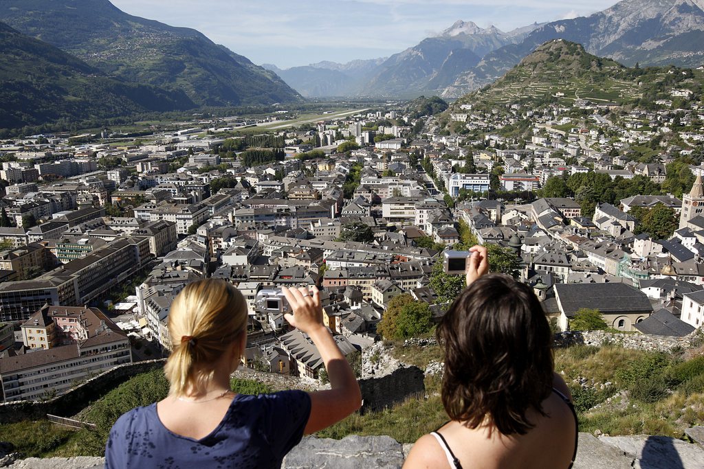Deux personnes photographie la ville de Sion depuis la chateau de Valere ce lundi 8 septembre 2008 a Sion. (KEYSTONE/Jean-Christophe Bott)