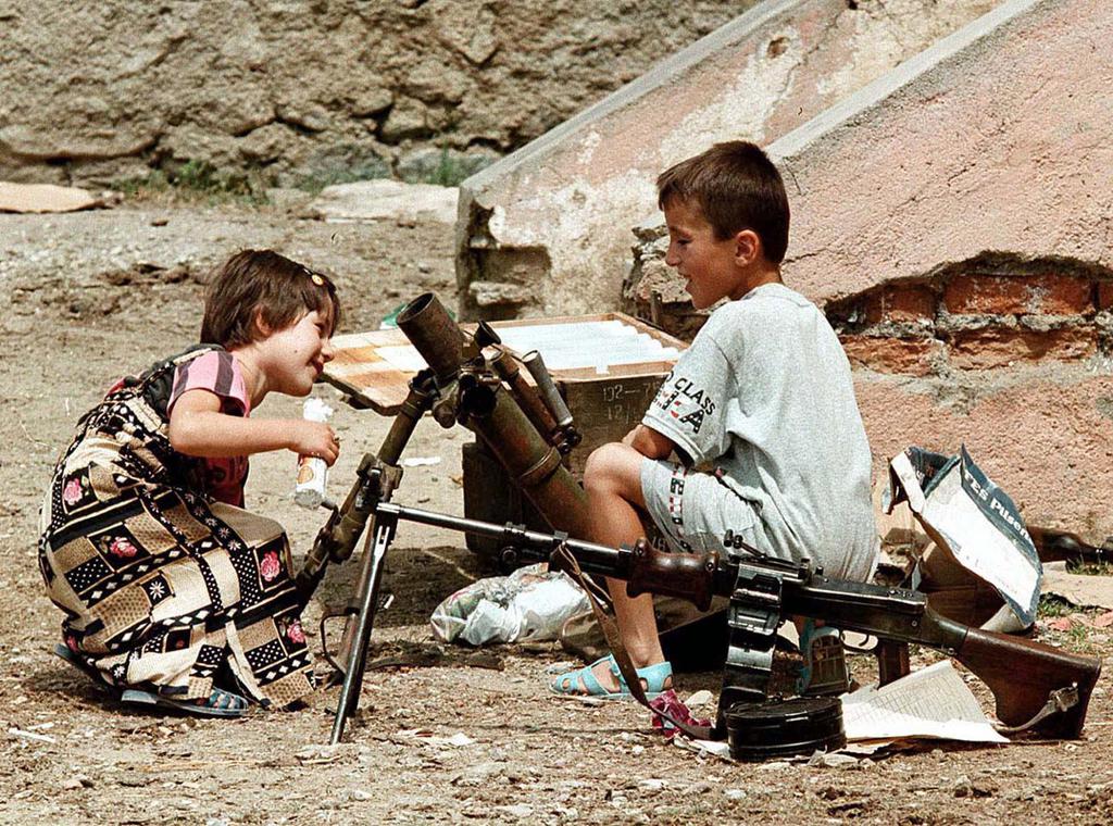 BAJ01-19980623-TROPOJE, ALBANIA: Local children play with a mortar launcher and a machine gun on a square in Tropoje, 23 June 1998. The small village in northern Albania, close to the border with Kosovo, has become a trafficking center for all kinds of weapons and arms from where they are smuggled to the troubled southern Serbian province of Kosovo to end up in the arsenals of the Kosovo Liberation Armu (UCK) and being used in the UCK guerilla war against Serbian Forces.       EPA PHOTO       EPA/LOUISA GOULIAMAKI/lg/kr