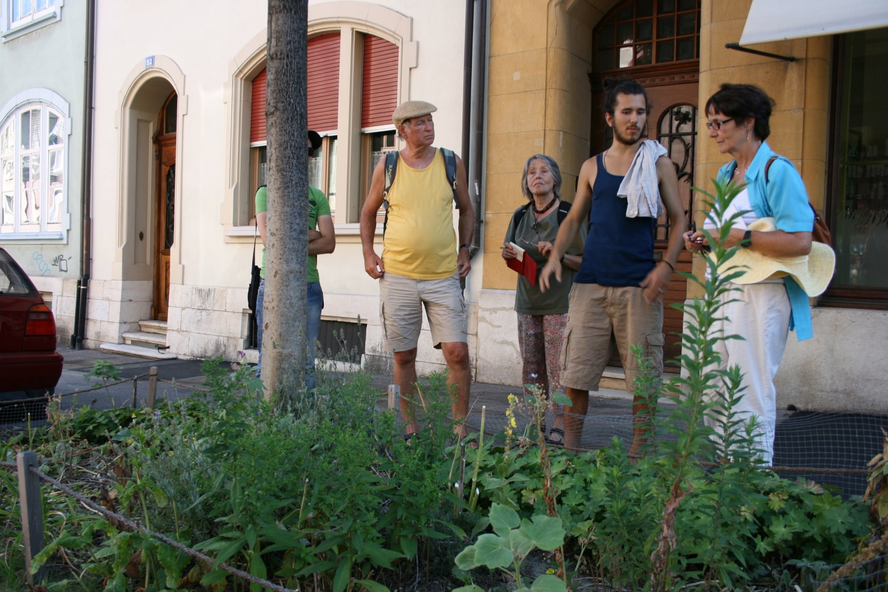 Des Verts morgiens écoutent les explications de Bastiaan Frich (t-shirt bleu) au sujet d'un coin de terre transformé en jardin et géré par un habitant du quatier. Bâle le 15.08.2012.