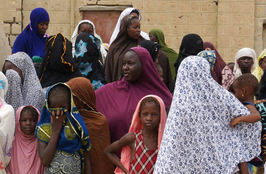 Des femmes maliennes, voilées, attendent d'assister à l'amputation d'un homme accusé de viol. 