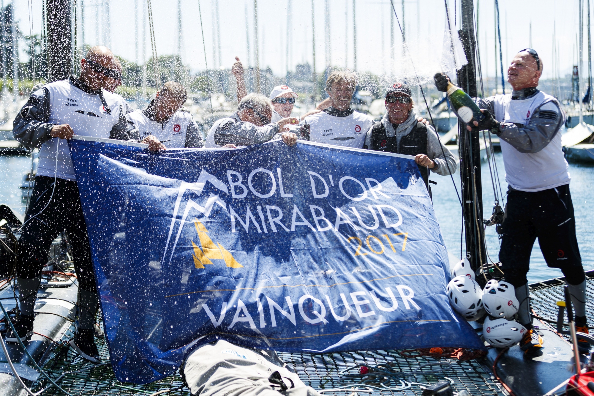 Crew members of "Alinghi 1" M1 class, D35 sailboat celebrate with champagne after winning the 79th "Bol d'Or" sailing race in 5 hours 11 minutes and 6 seconds on Lake Geneva, in Geneva, Switzerland, on Saturday, June 17, 2017. About 550 boats participate in this weekend's Bol d'Or, the largest sailing race held on a lake in Europe. (KEYSTONE/Valentin Flauraud)