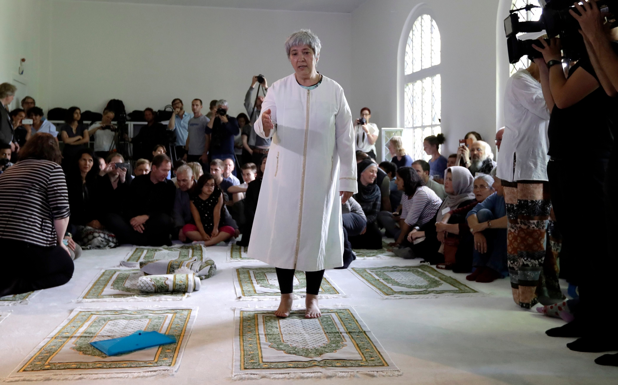 Seyran Ates, standing at center, founder of the Ibn-Rushd-Goethe-Mosque gestures during the opening of the mosque in Berlin, Germany, Friday, June 16, 2017. Ates the 54-year-old daughter of Turkish immigrants has founded the first liberal mosque in Germany where men and women can pray together, homosexuals are welcome and Muslims of all sects can leave their inner-religious conflicts behind. (AP Photo/Michael Sohn) GERMANY