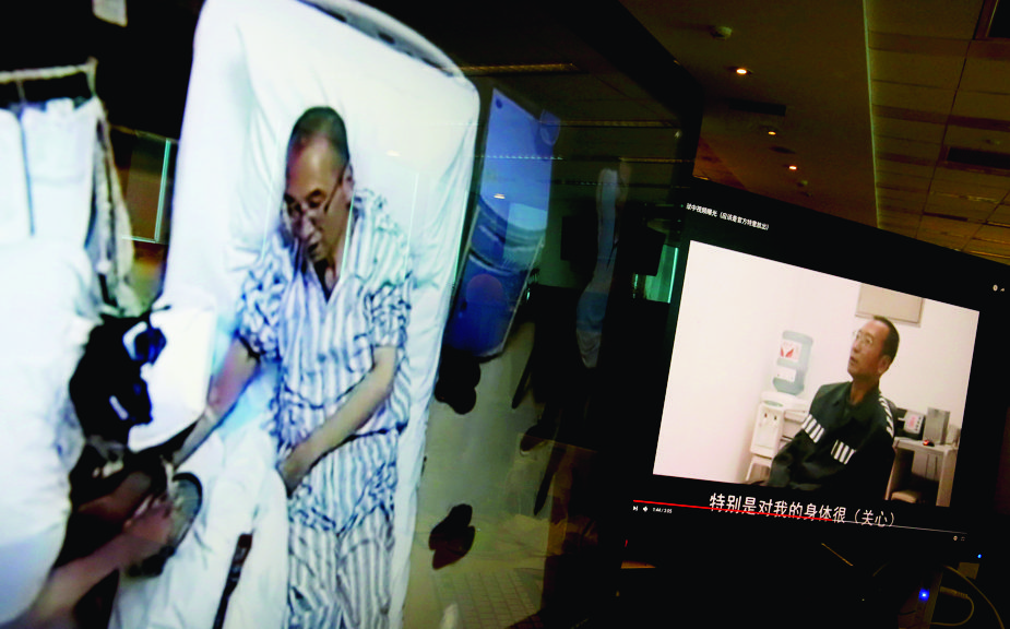 Video clips show China's jailed Nobel Peace laureate Liu Xiaobo lying on a bed receiving medical treatment at a hospital, left, and Liu saying wardens take good care of him, on a computer screens in Beijing, Thursday, June 29, 2017. An online video without clear provenance but certainly shot by Chinese authorities has shown Liu thanking wardens for taking care of his health, in an apparent response to criticisms that Beijing has failed to provide sufficient health care to China's most prominent political prisoner. (AP Photo/Andy Wong) China Jailed Nobel Laureate